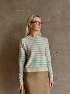 Mature woman wearing Guest in Residence Pebble cream and sage stripe shrunken crew long sleeve cashmere sweater