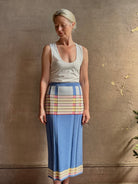 Mature woman wearing Plaited Rib knit pencil Skirt from Guest in Residence rendered in delft blue and crafted from a luxurious blend of silk, linen, nylon, and elastane with wide rib texture down front and back with pink and yellow horizontal stripes at hips and bottom edge