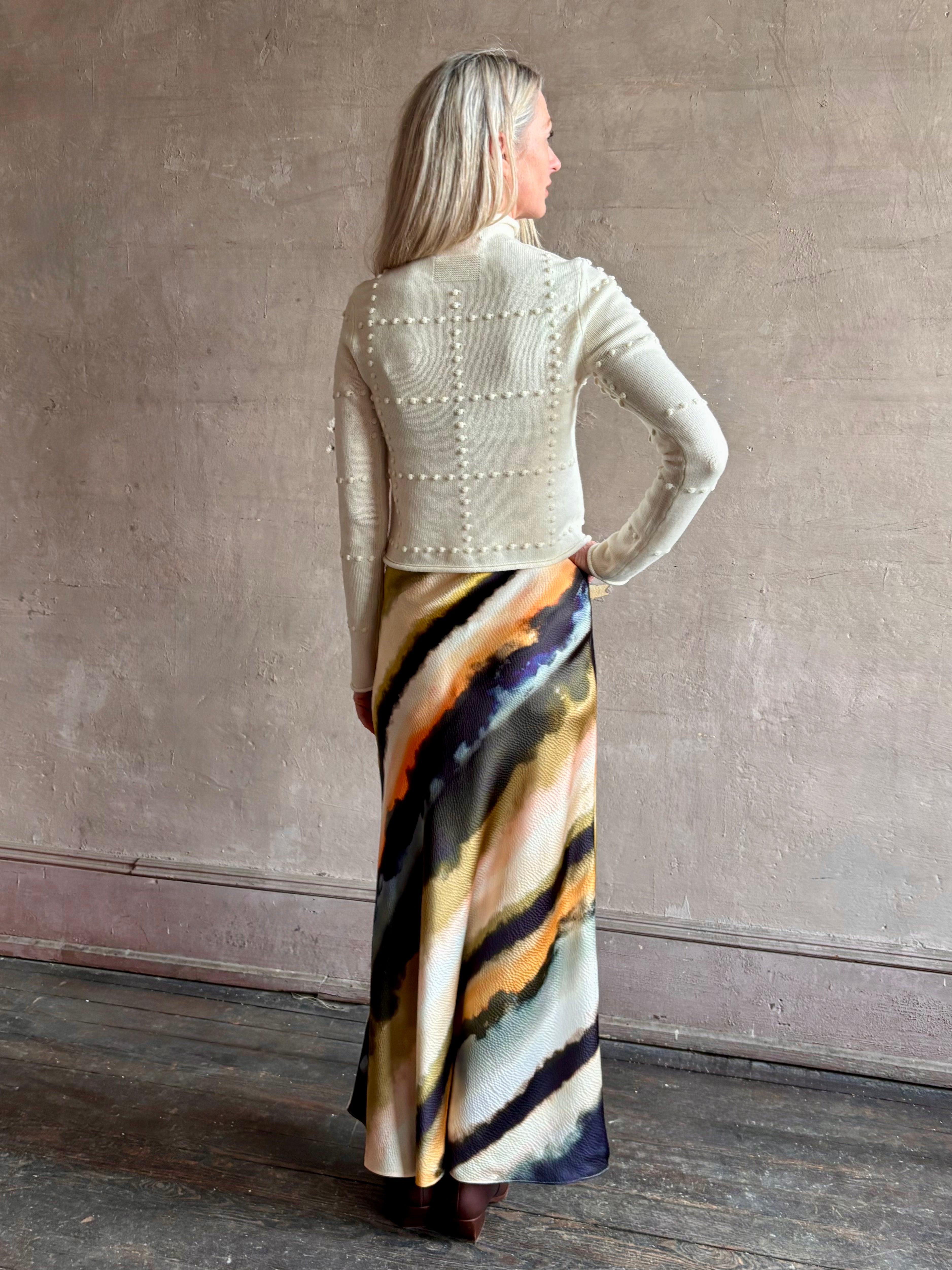 Image of mature woman wearing a cream cashmere blend sweater from NYC based celebrity brand Guest in Residence with geometric texture pattern