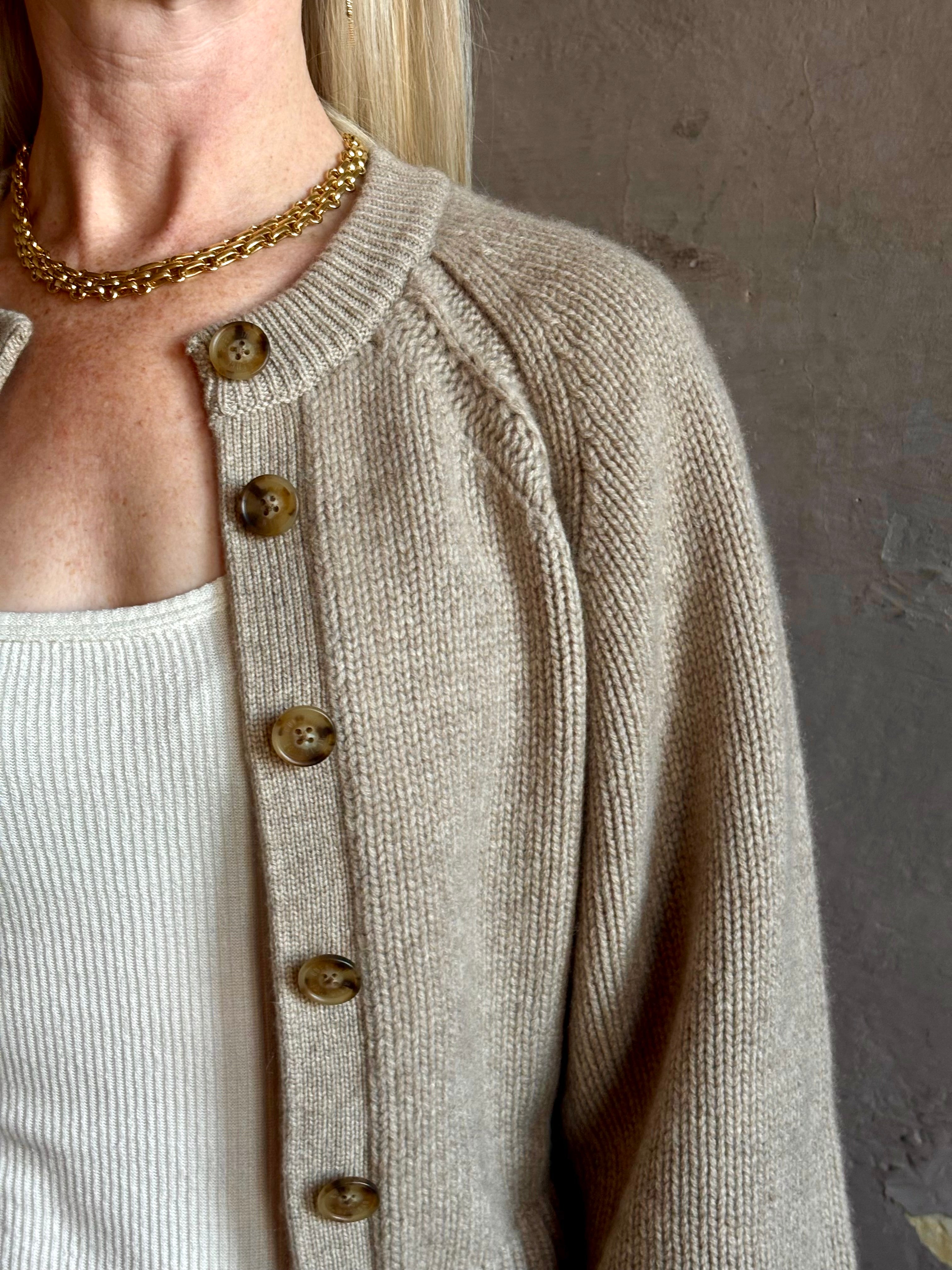 Mature woman wearing Guest in Residence Sculpted Cardigan in Taupe medium gauge cashmere raglan sleeves button front fitted waist softly structured