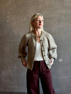 Mature woman wearing Guest in Residence Sculpted Cardigan in Taupe medium gauge cashmere raglan sleeves button front fitted waist softly structured