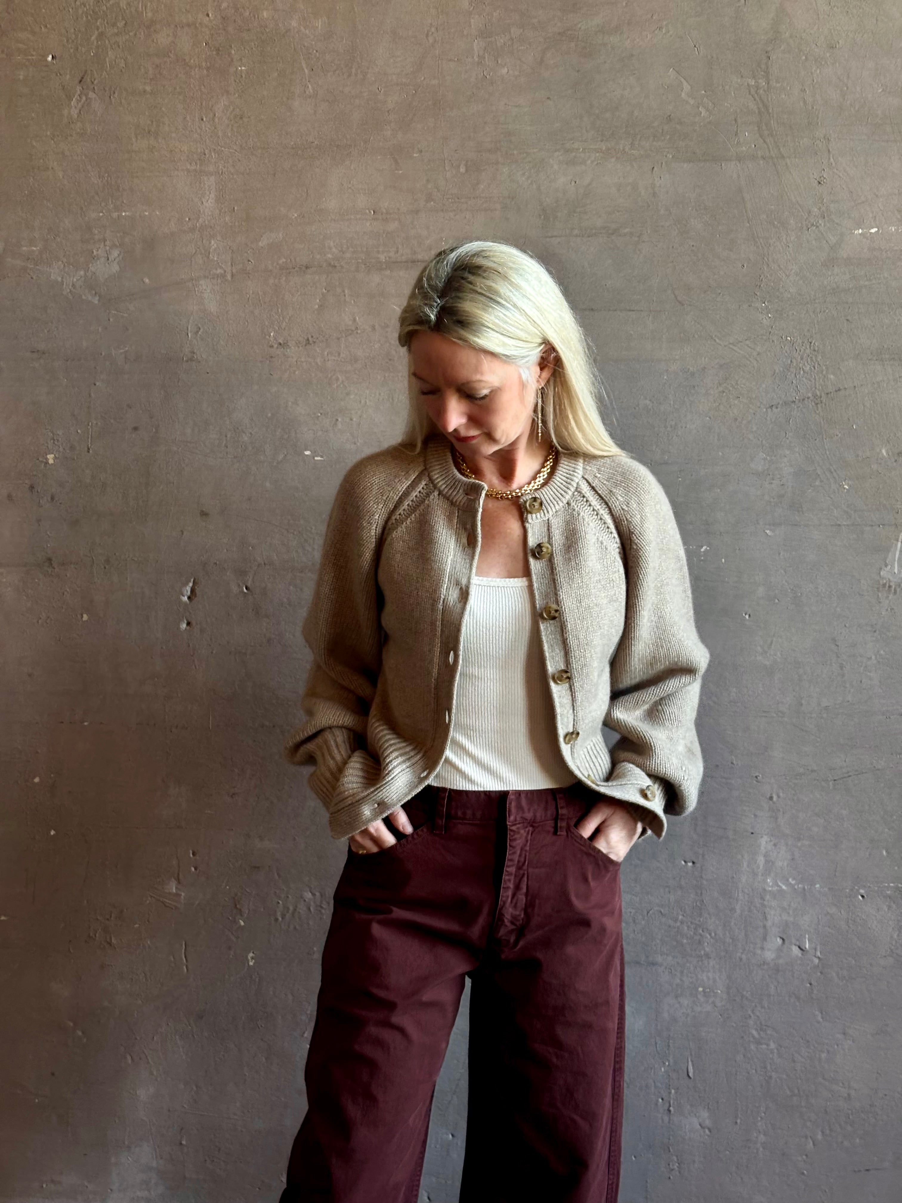 Mature woman wearing Guest in Residence Sculpted Cardigan in Taupe medium gauge cashmere raglan sleeves button front fitted waist softly structured