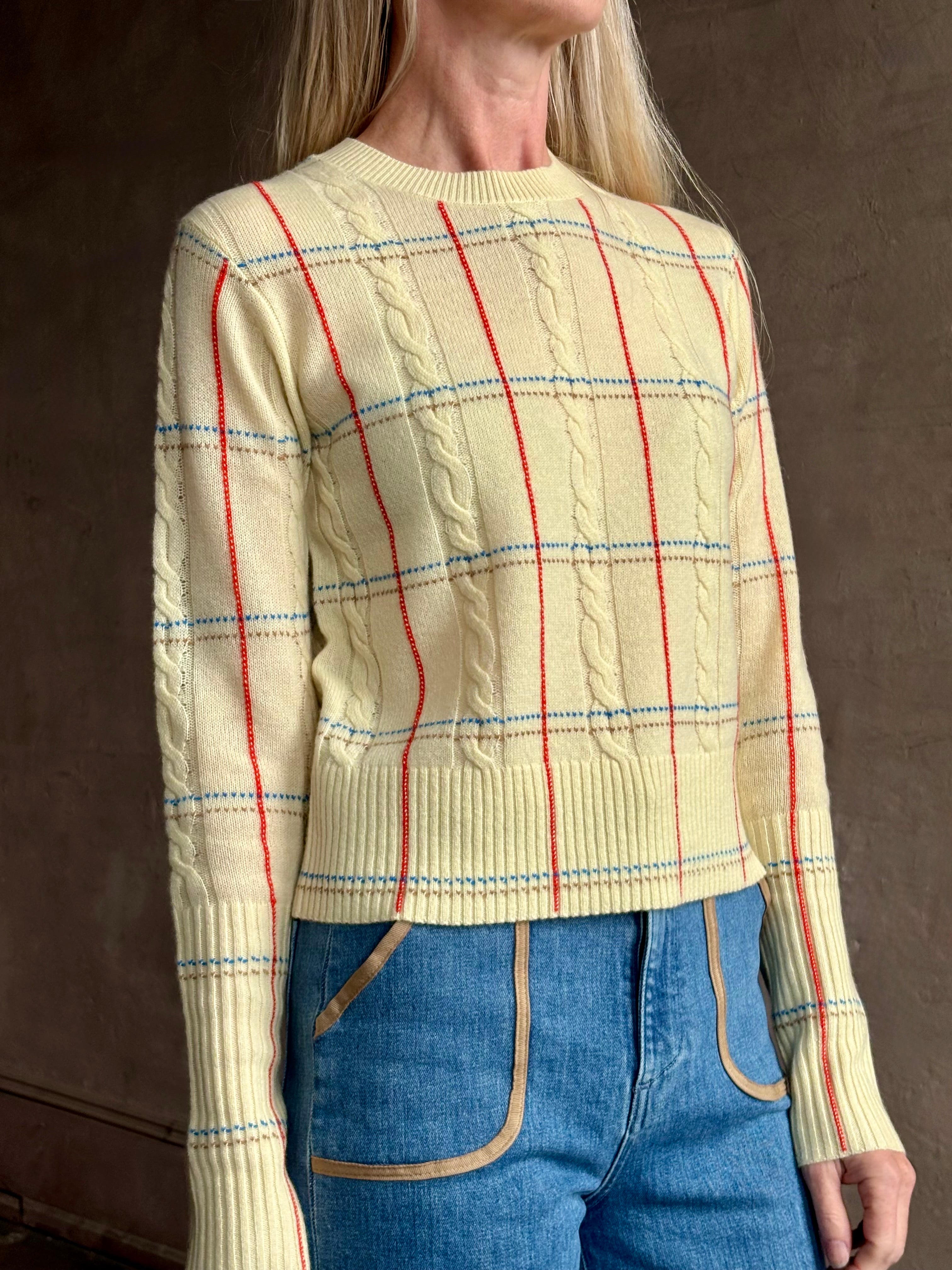 Image of woman wearing designer Guest in Residence yellow combo sweater with cable texture and subtle red, blue and beige plaid stripes pattern