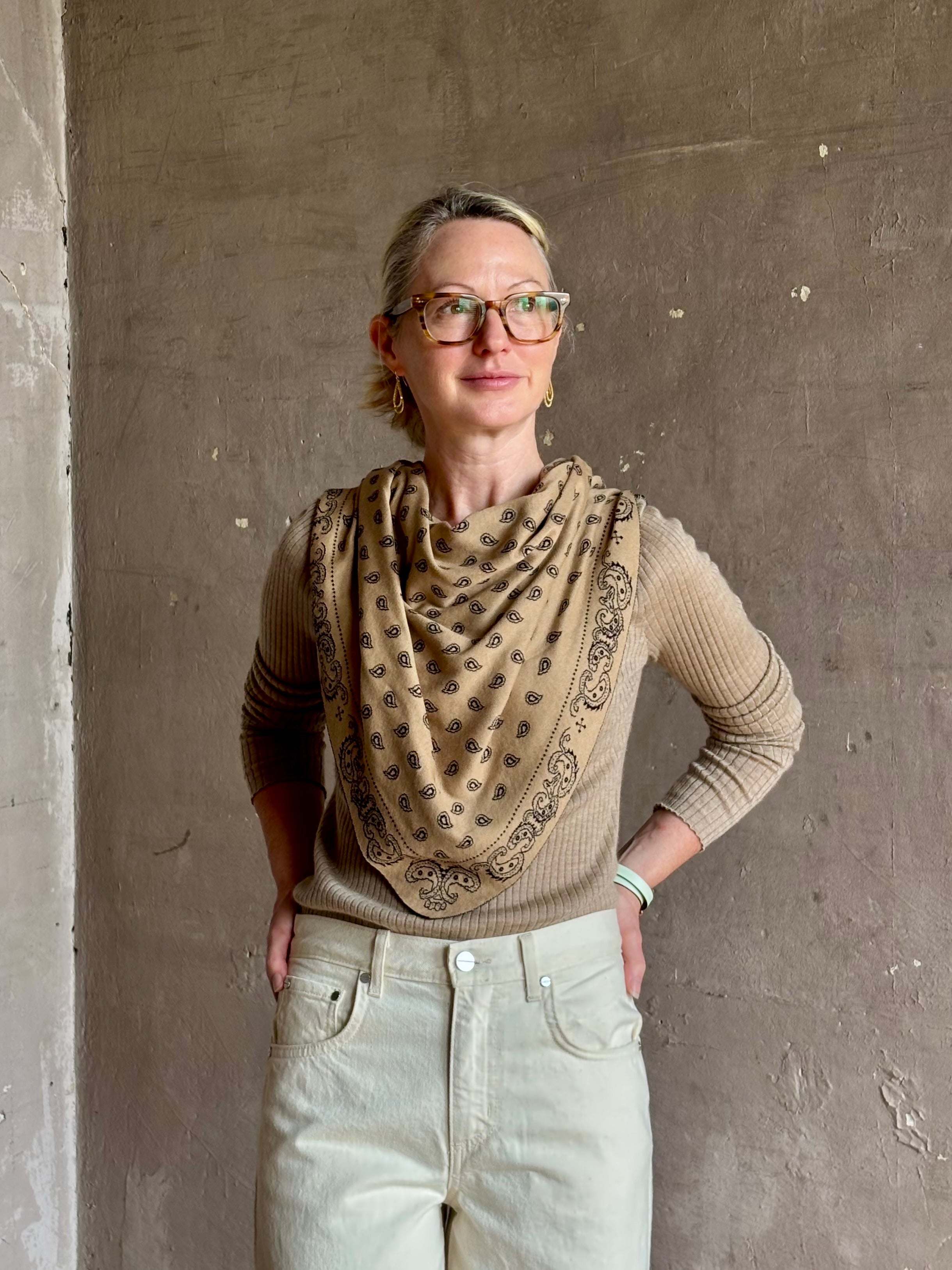 Mature woman wearing Guest in Residence The Wild Rag camel brown patterned bandana triangle reversible scarf