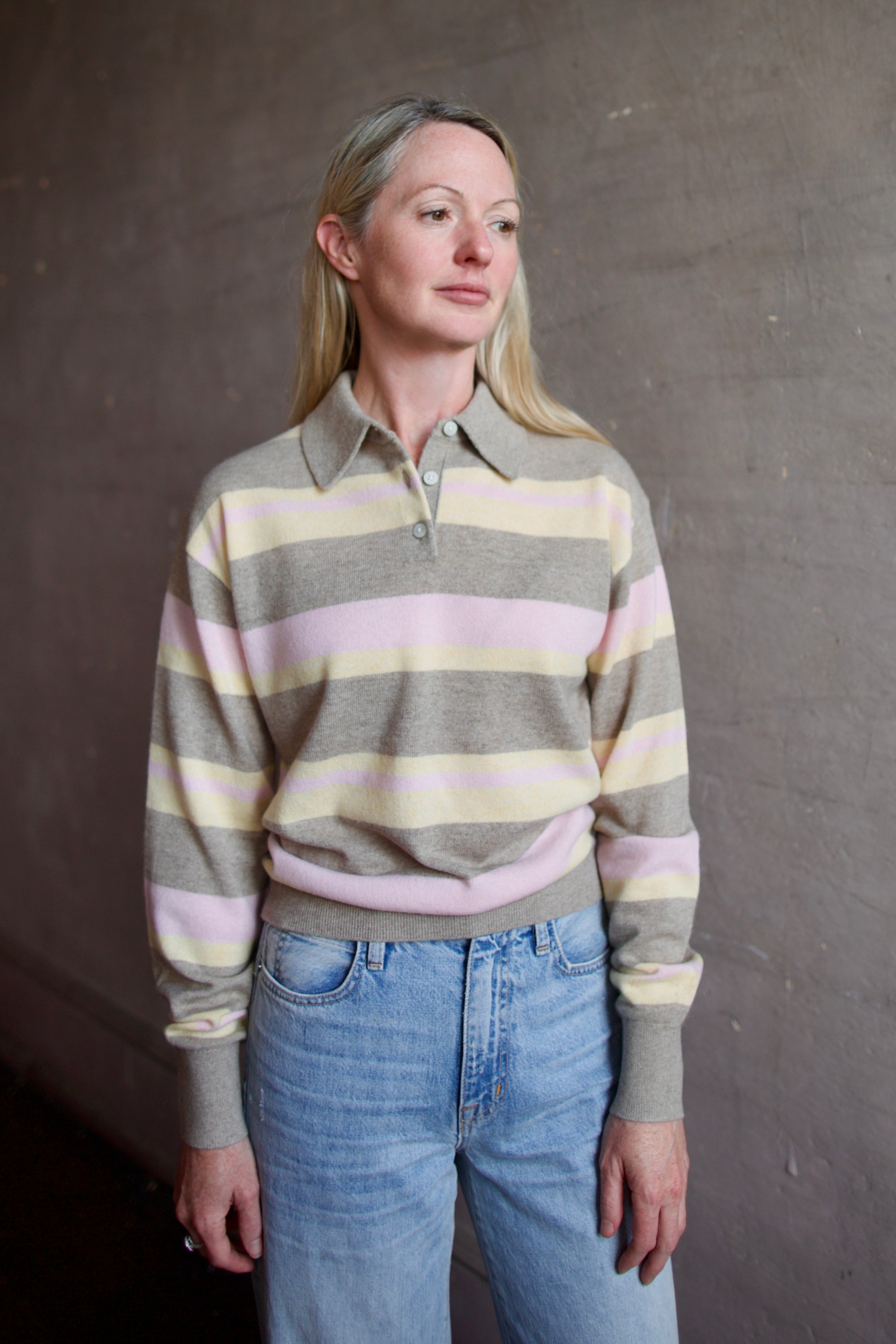 Image of model wearing a Guest in Residence striped cashmere sweater and jeans against a plain background