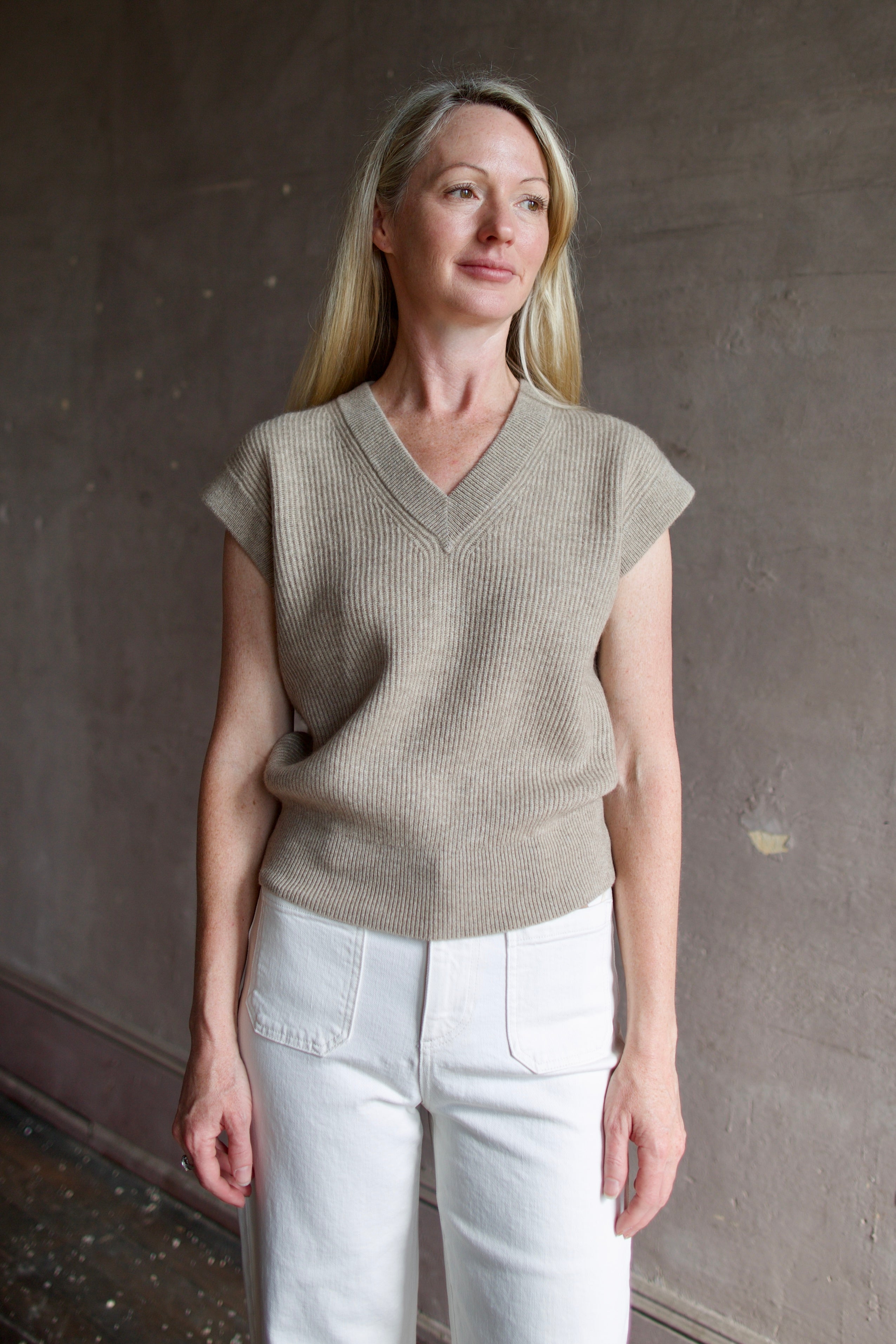 Mature model wearing premium designer Guest in Residence taupe Rib Vest with v-neck and luxury Mongolian cashmere fabrication