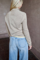 Woman wearing a taupe effortless layering stealth cashmere cardigan by Guest In Residence for timeless elegance