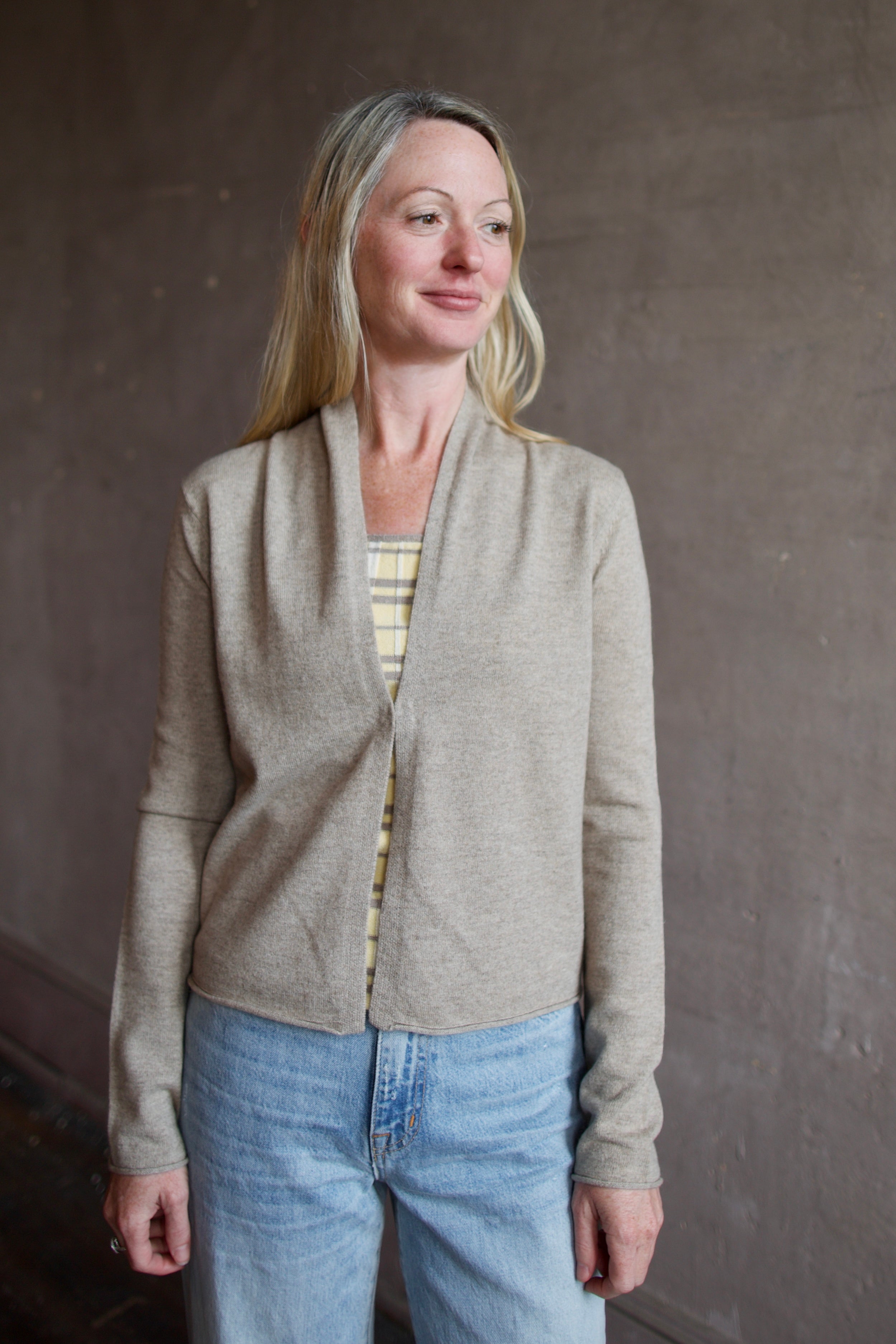 Woman wearing a taupe effortless layering stealth cashmere cardigan by Guest In Residence for timeless elegance