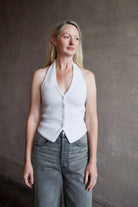 Image of model wearing a white cashmere halter top vest with veronica beard gray denim