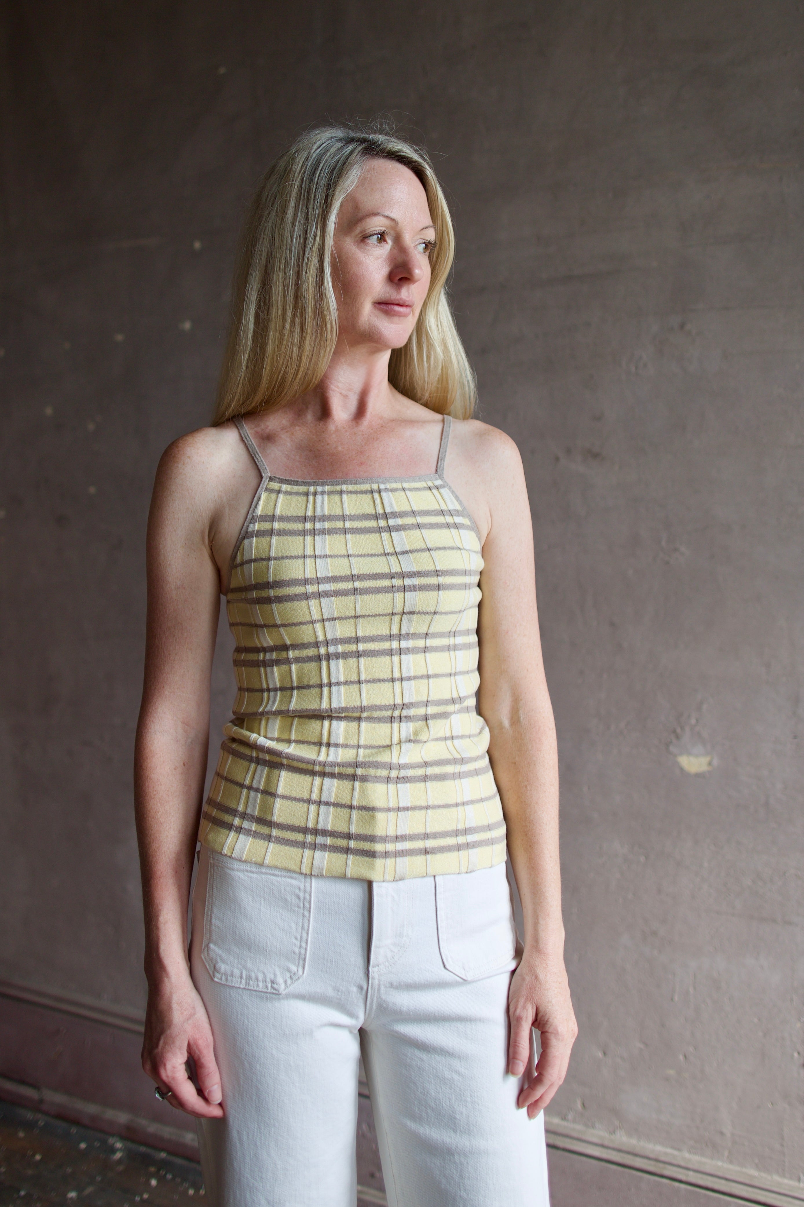 Model wearing premium designer Guest in Residence Plaid Tank top in butter yellow with taupe and white plaid pattern in lightweight silk linen blend