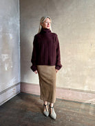 Woman wearing oversized Guest in Residence Super Cloud T Neck cashmere-silk boucle knit sweater with a cable pattern, long sleeves and funnel neck in fig