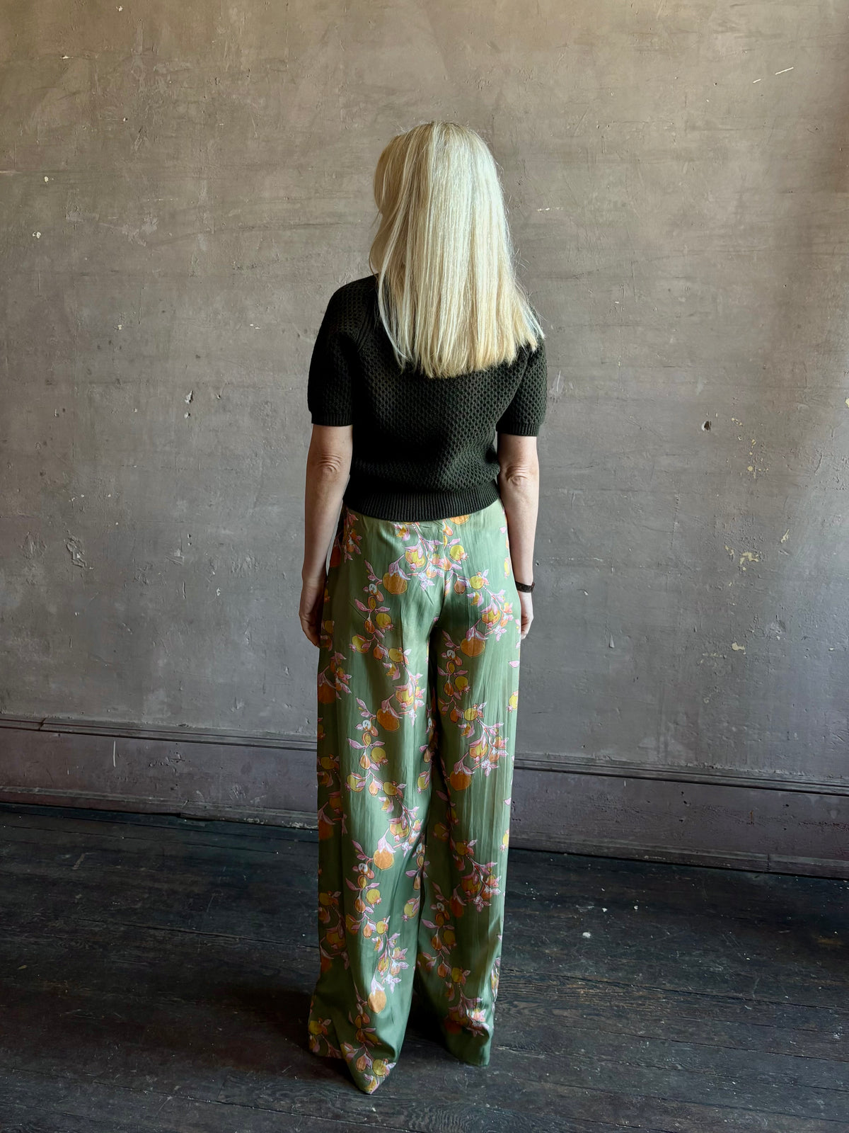 Mature woman wearing Hannah Artwear Azra silk Pant Khaki habotai with vibrant pomegranate print relaxed straight leg Fluid artisan-printed 