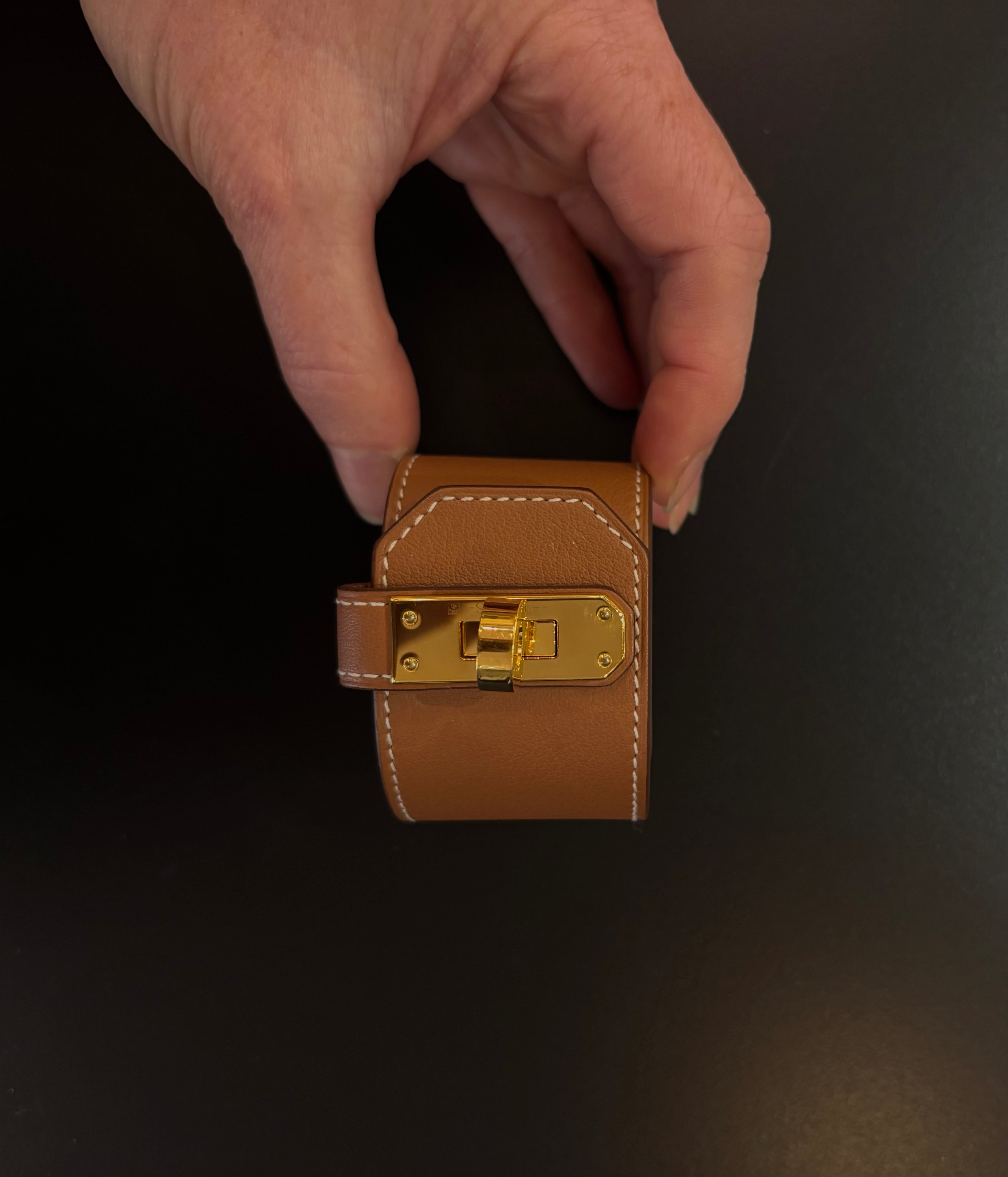 Hermès Kelly Twist Bracelet Brown & Yellow Gold: swift leather gold-plated Kelly turn-lock hardware hand assembled in France Pristine never-worn collector icon
