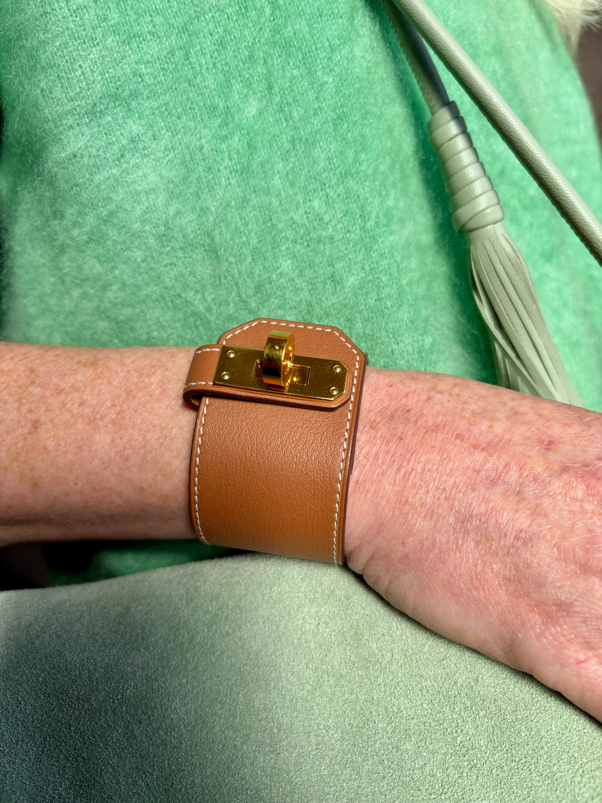 Hermès Kelly Twist Bracelet Brown & Yellow Gold: swift leather gold-plated Kelly turn-lock hardware hand assembled in France Pristine never-worn collector icon