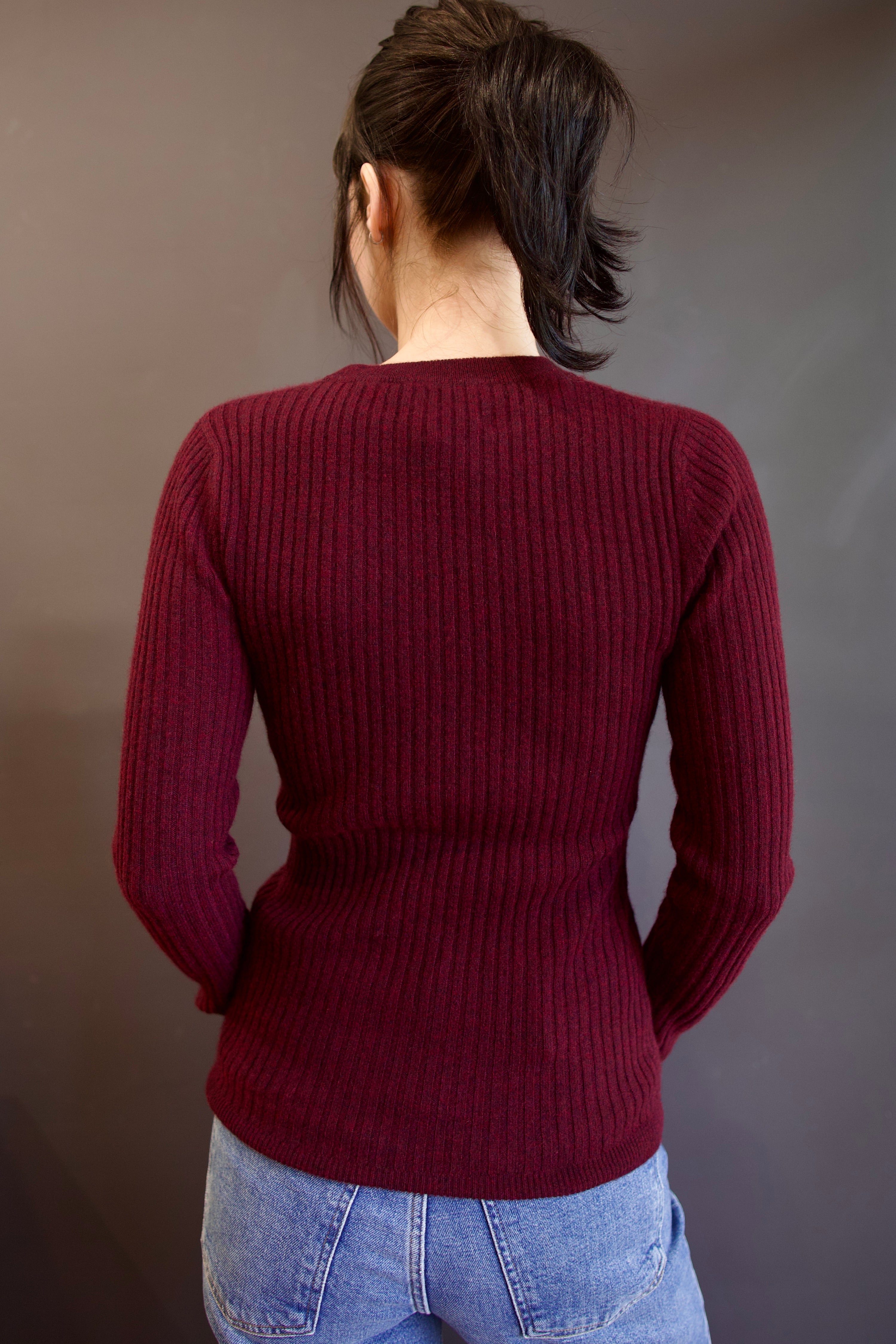 Model wearing luxury french brand Kujten Bibi ribbed cashmere sweater in bordeaux with long sleeves and crew neck.