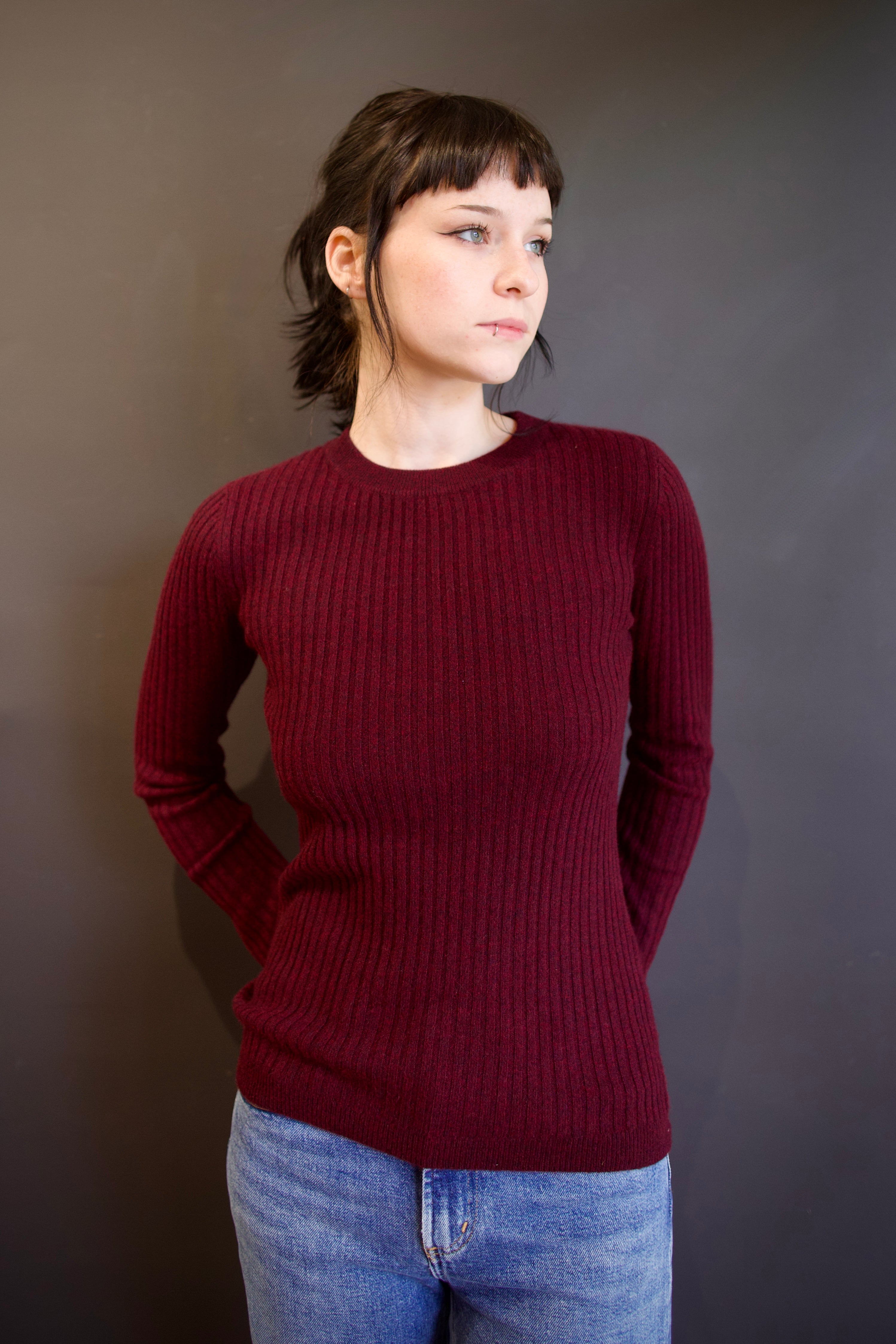 Model wearing luxury french brand Kujten Bibi ribbed cashmere sweater in bordeaux with long sleeves and crew neck.