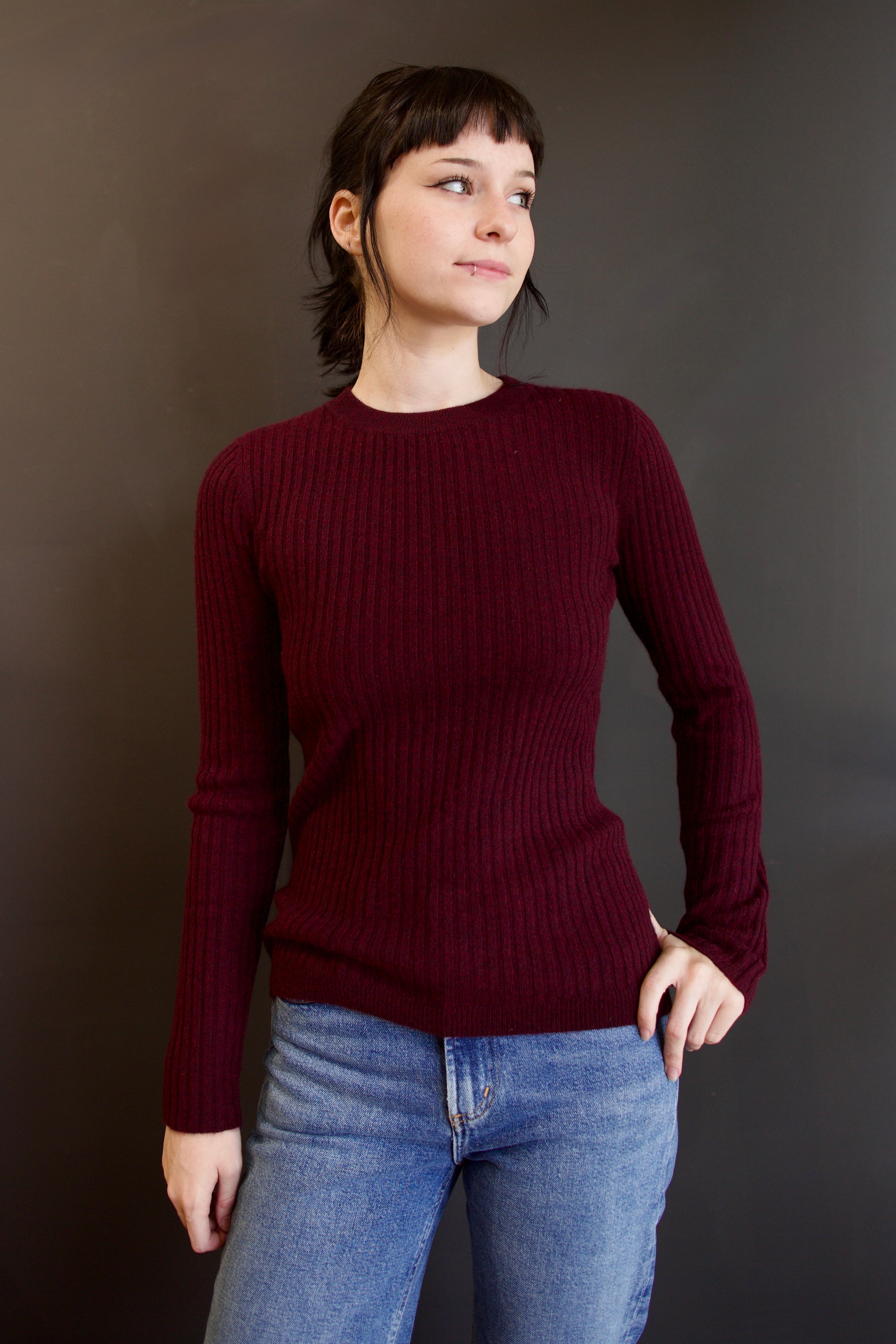 Model wearing luxury french brand Kujten Bibi ribbed cashmere sweater in bordeaux with long sleeves and crew neck.
