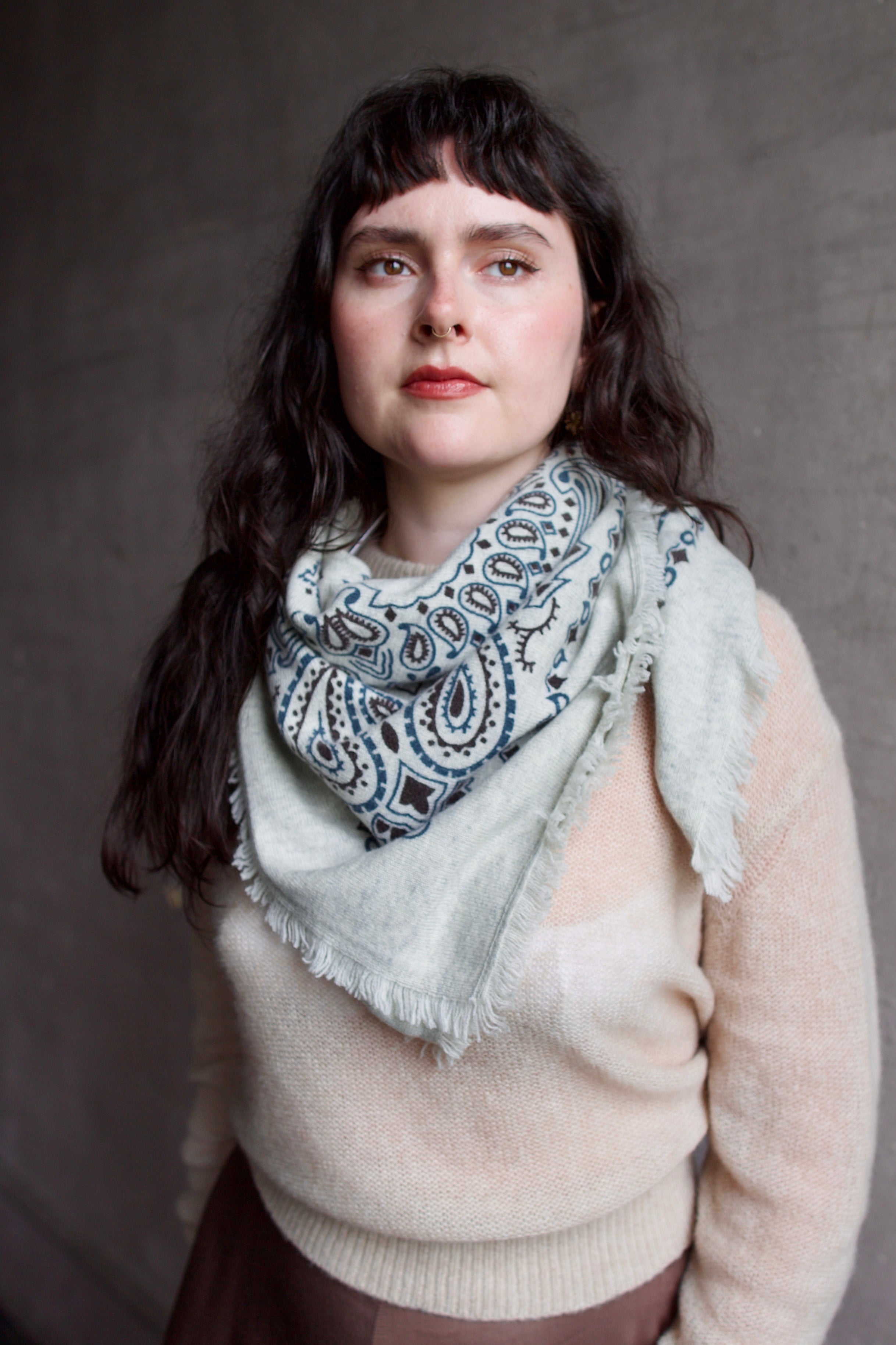 Model wearing a cream sweater with large patterned Kujten premium cashmere bandana printed scarf 