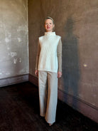 Mature woman wearing Kujten's Erika Funnel Neck Sweater in Off-White  cashmere Parisian luxury layering side snap closure intricate modern design