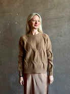 Mature woman wearing Kujten's Nils Cashmere Sweater Camelo Brown  long sleeves crew neckline cable knit Parisian luxury