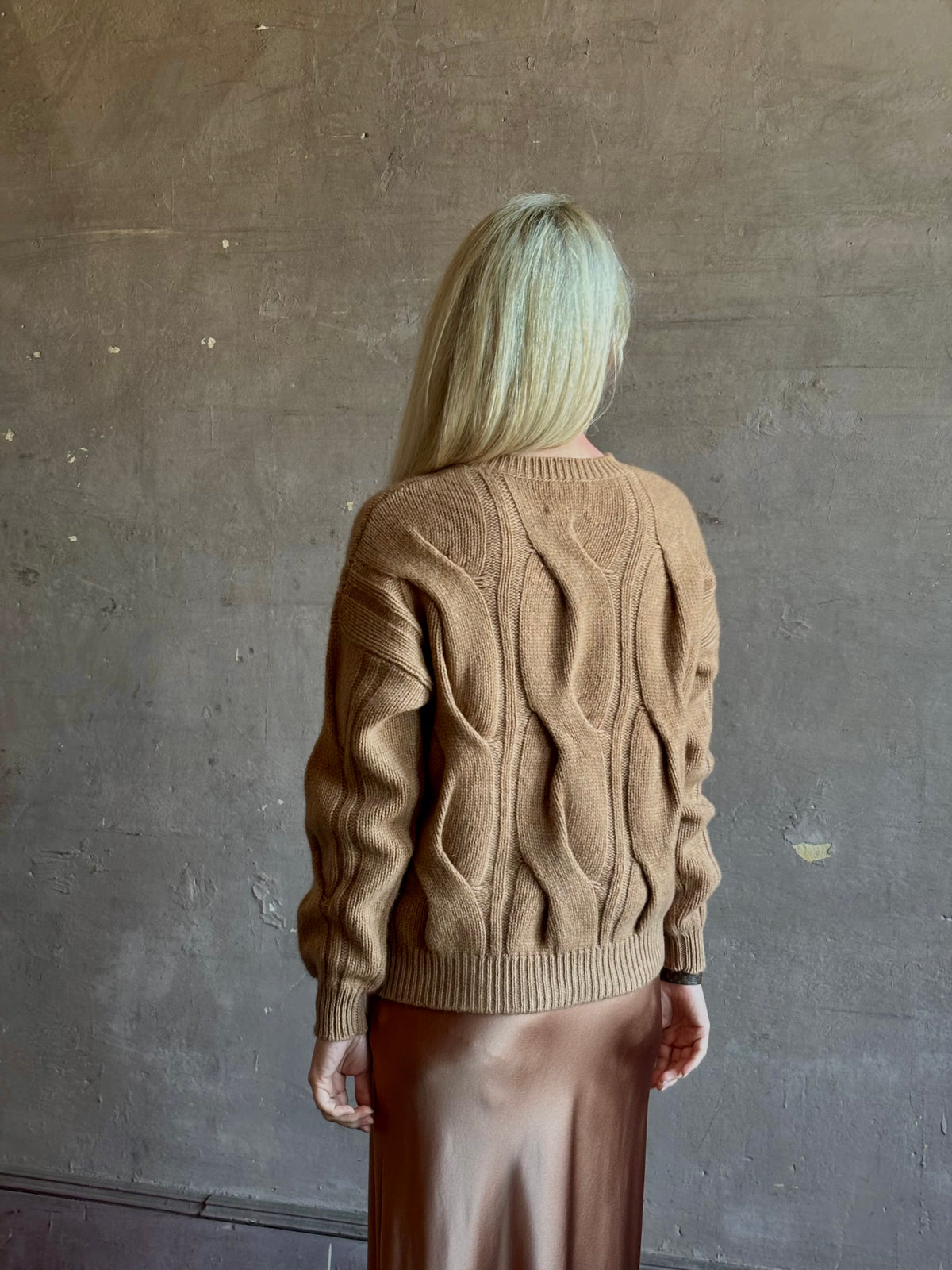 Mature woman wearing Kujten's Nils Cashmere Sweater Camelo Brown  timeless sculptural textured cable knit Parisian luxury