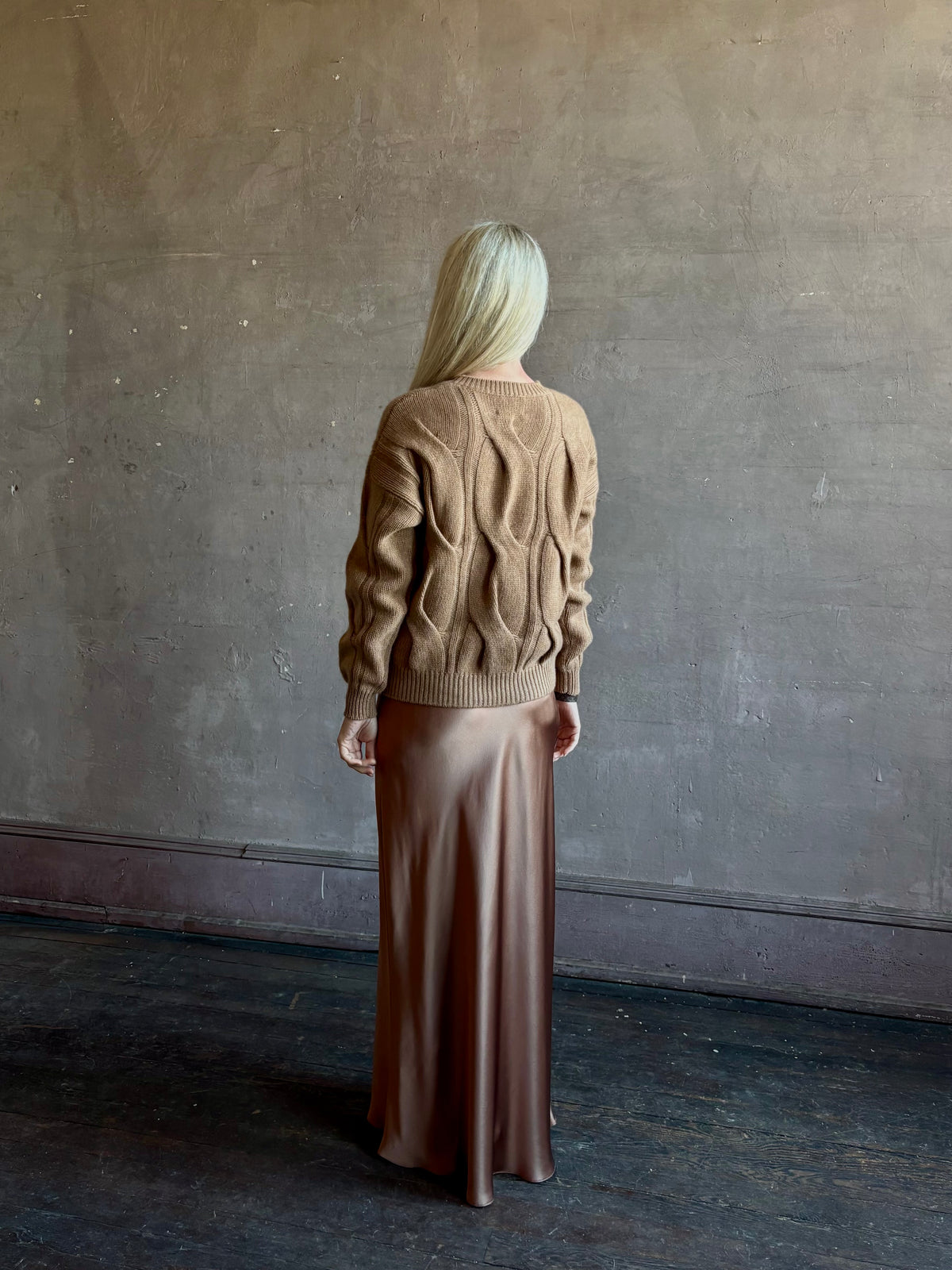 Mature woman wearing Kujten's Nils Cashmere Sweater Camelo Brown  timeless sculptural textured cable knit Parisian luxury