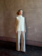 Mature woman wearing Kujten's Erika Funnel Neck Sweater Off White intricate modern design elegant Parisian luxury layering