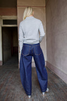 Mature model wearing dark blue Rachel Comey barrel jeans and a gray TWP cashmere henley sweater 
