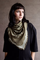 Image of model wearing luxury brand Kujten large  cashmere printed bandana in green colorway