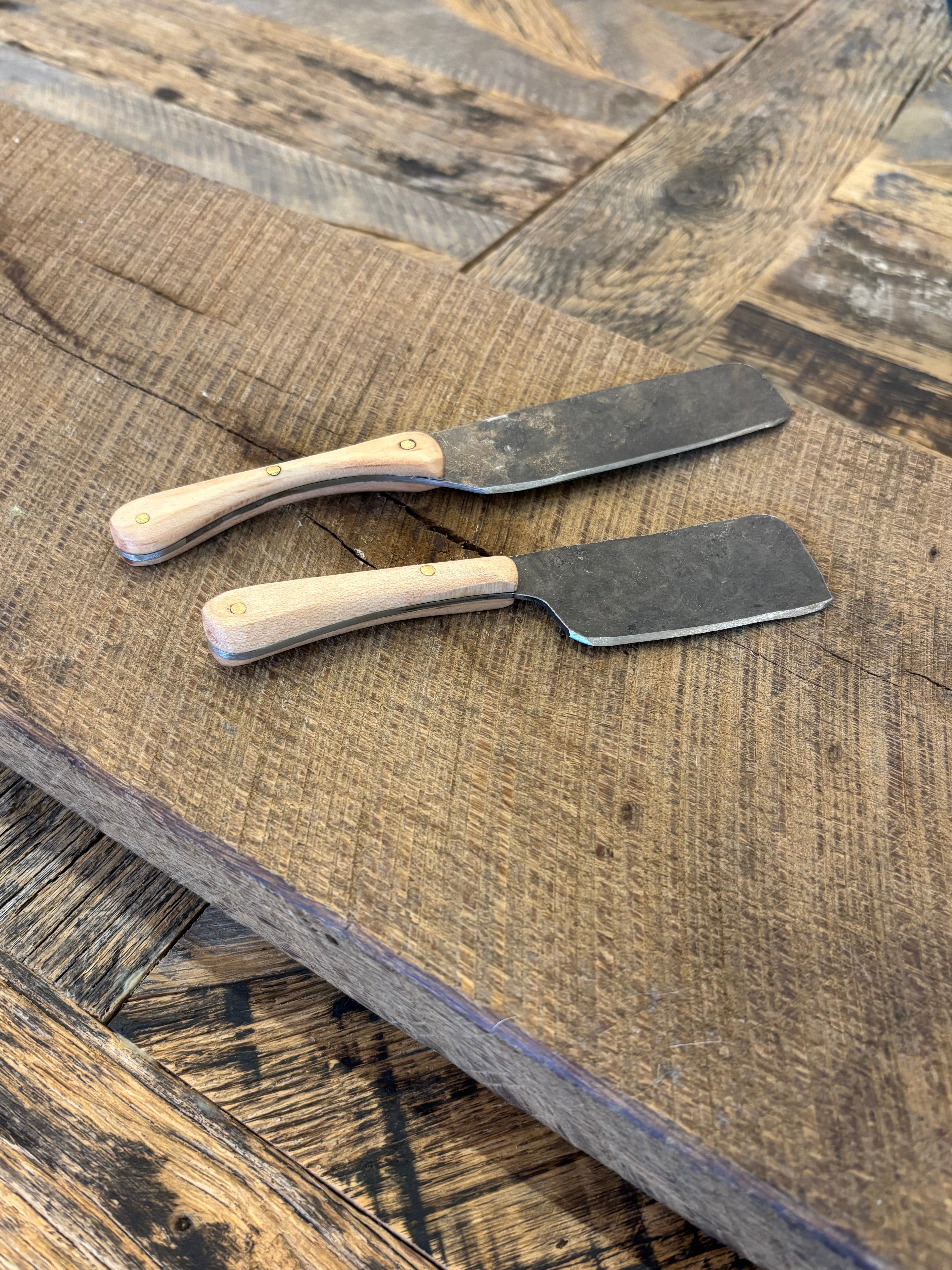 A rustic handcrafted charcuterie serving knife with a hand forged steel blade and  wooden maple handle made in USA