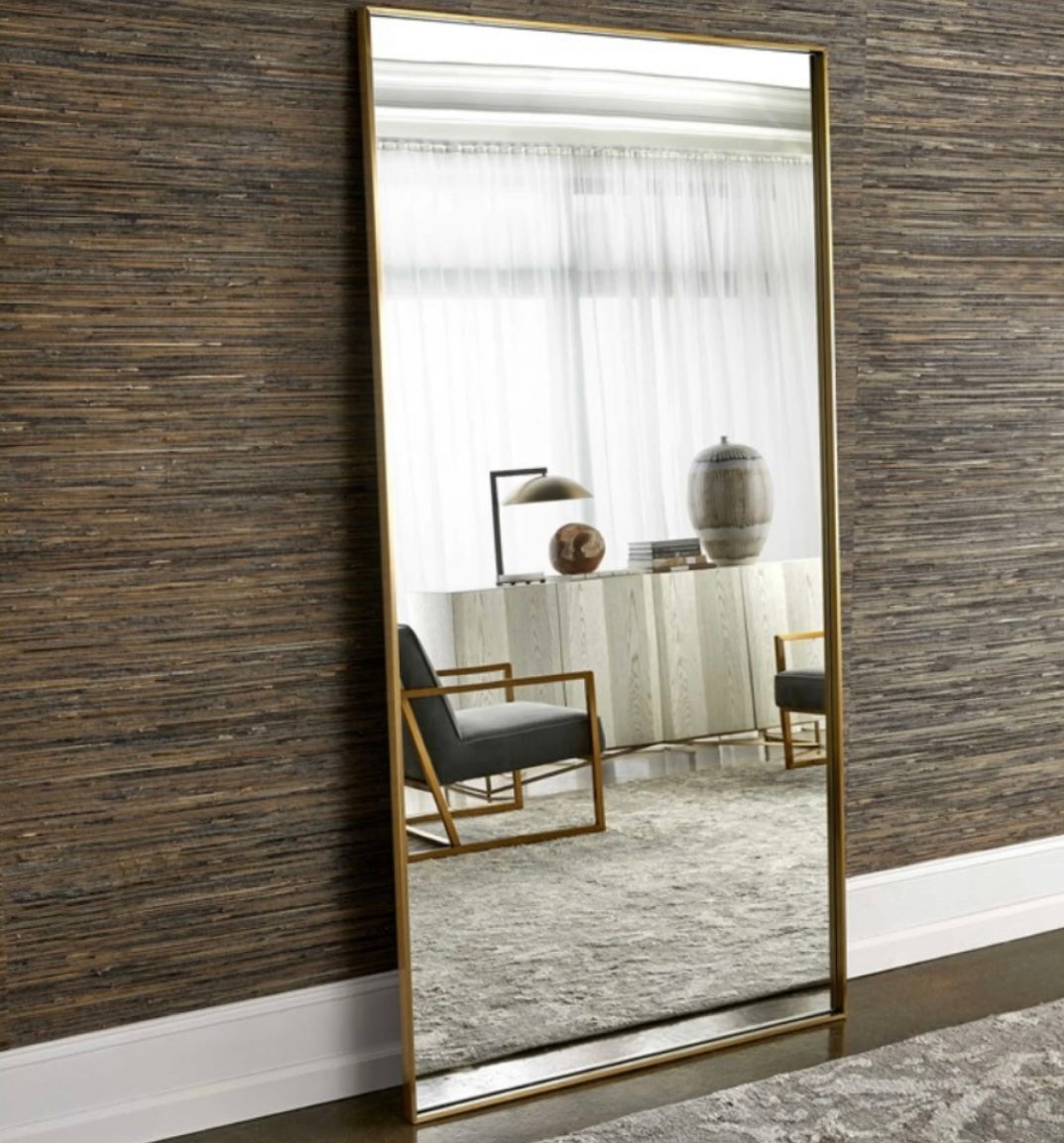 An oversized large rectangular brass wall mirror with a slim stainless steel frame.