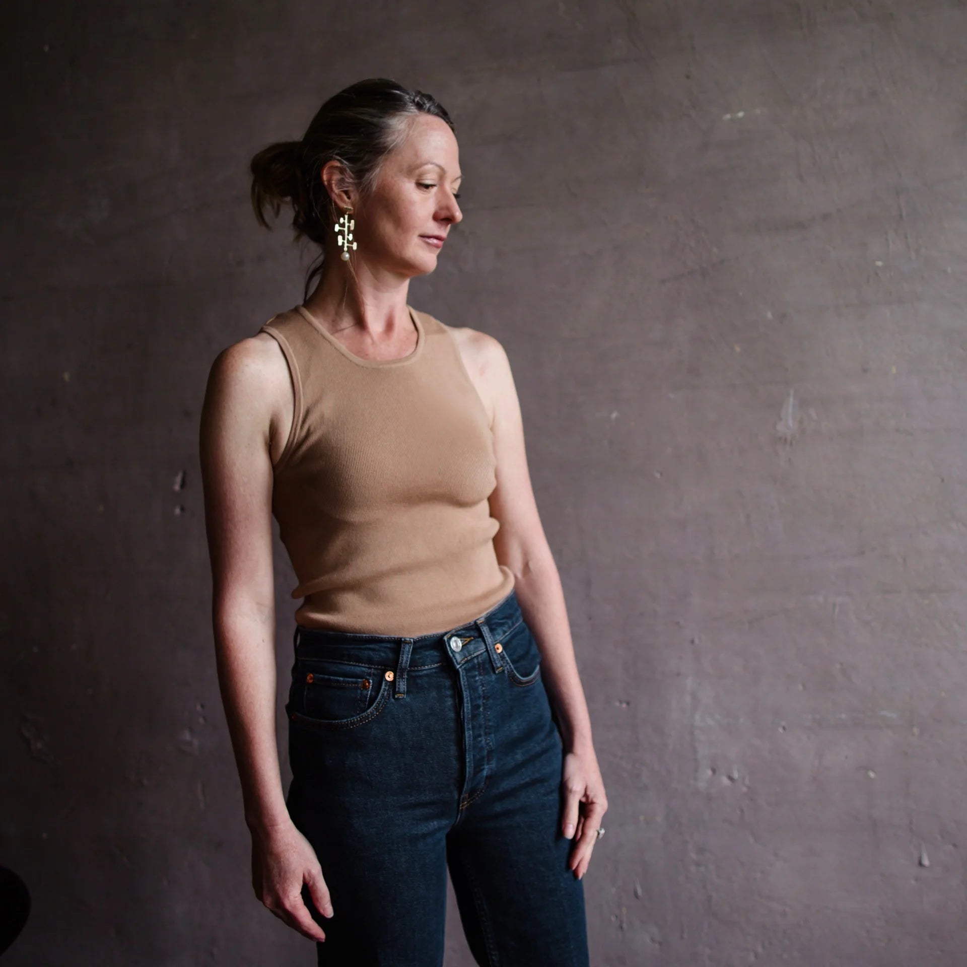 Image featuring a woman wearing the tan tanks a lot layering knit tank by Le Superbe with a round neck, sleeveless, and form fitting.