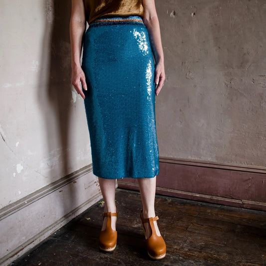 Image featuring a woman wearing the Le Superbe blue sequin midi skirt with stretchy fabric for ease of movement.