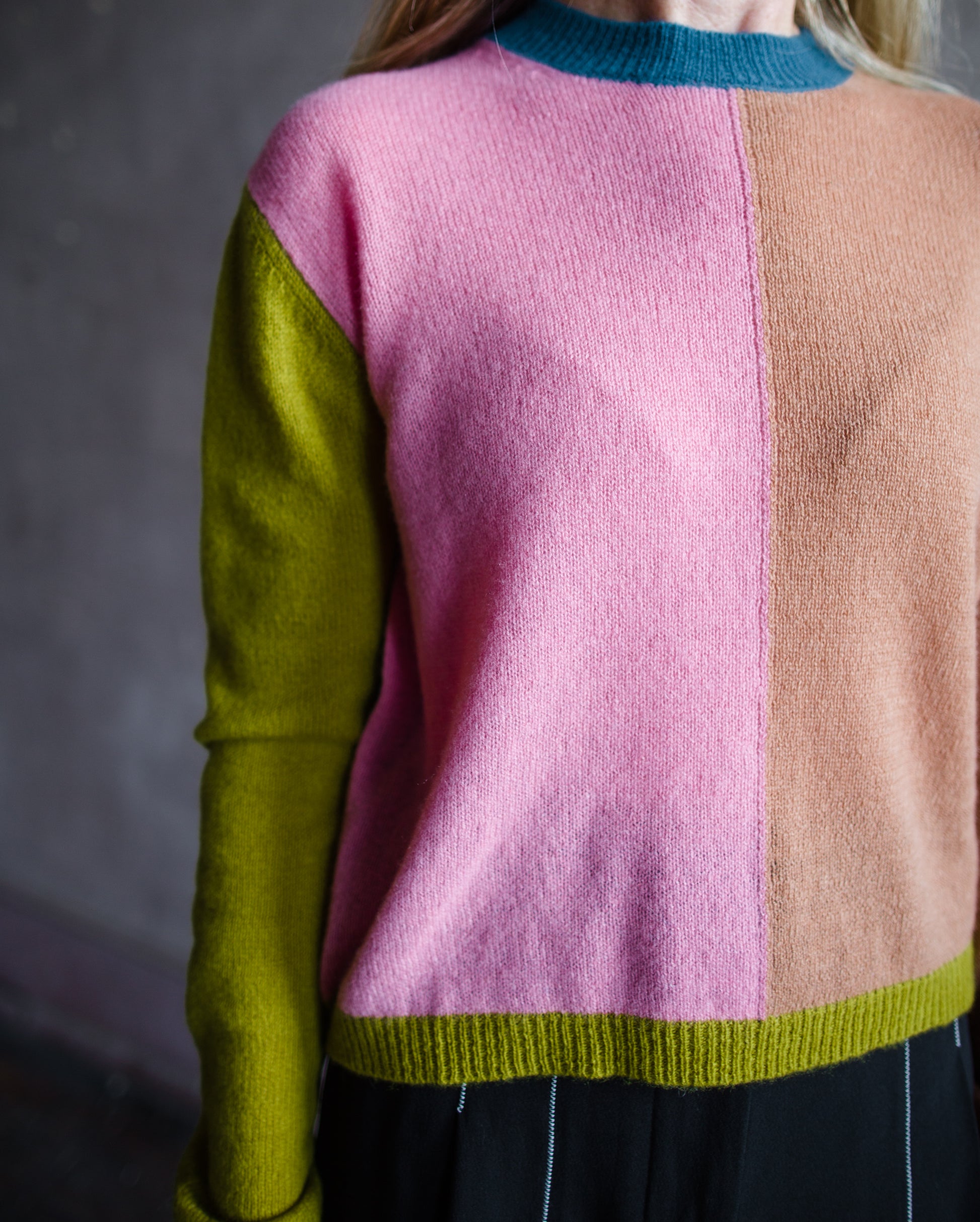 Close up image of a woman wearing the mondrian cashmere sweater by Le Superbe with a crew neckline, drop shoulders and a slightly relaxed fit.