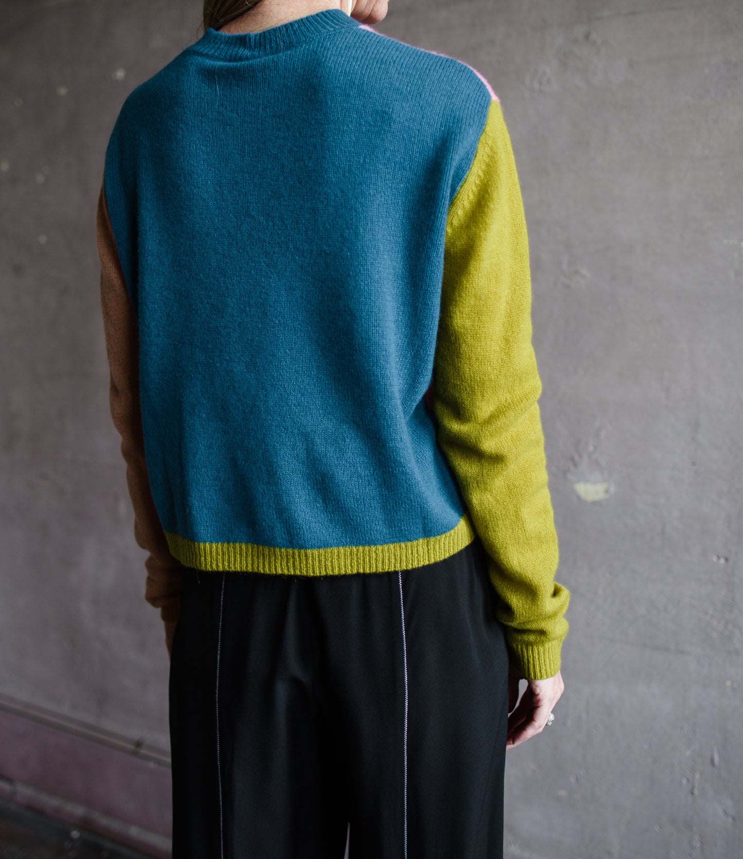 Close up image of a woman wearing the mondrian cashmere sweater by Le Superbe with a crew neckline, drop shoulders and a slightly relaxed fit.