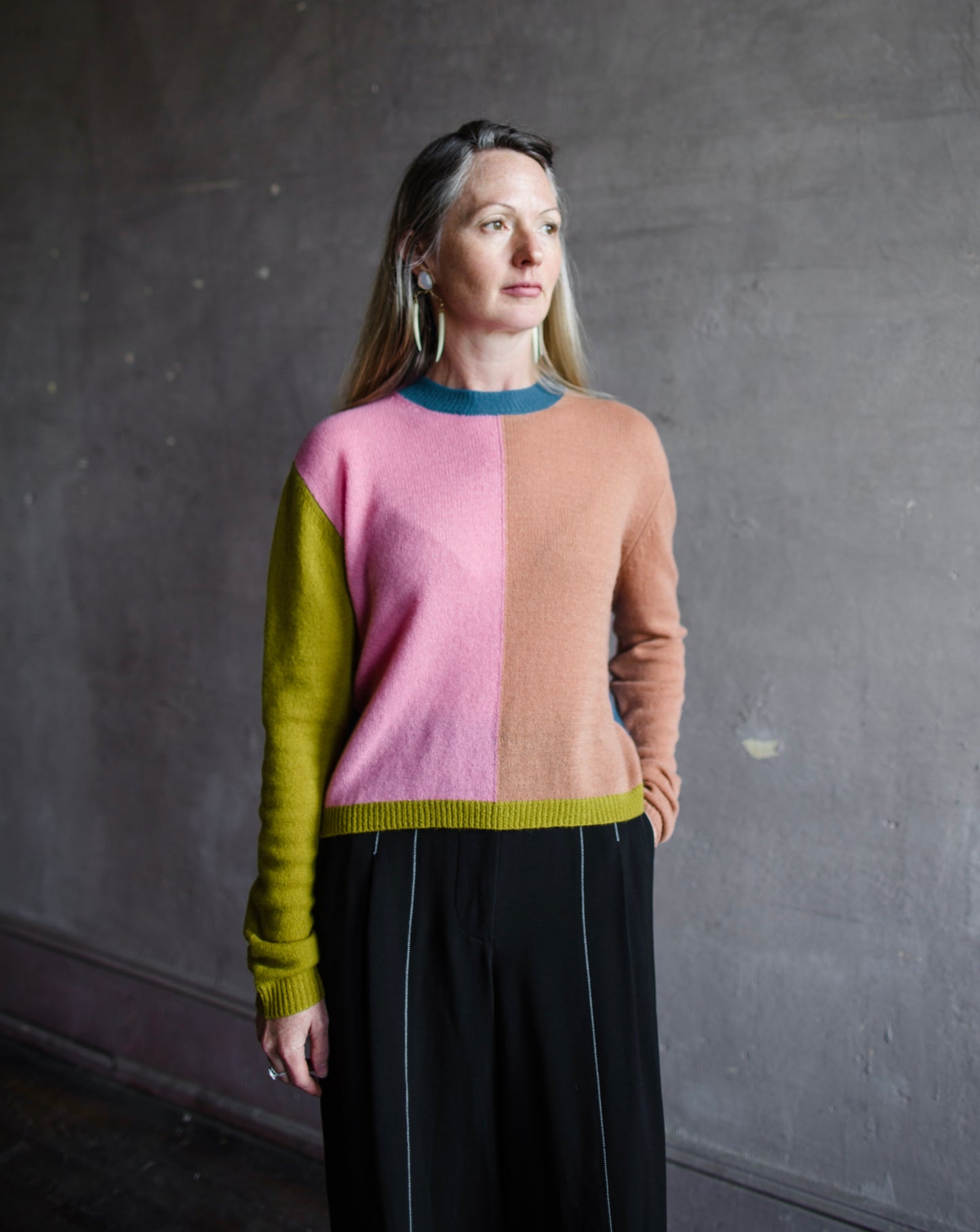 Image featuring a woman wearing the mondrian cashmere sweater by Le Superbe with a crew neckline with drop shoulders and a slightly relaxed fit.