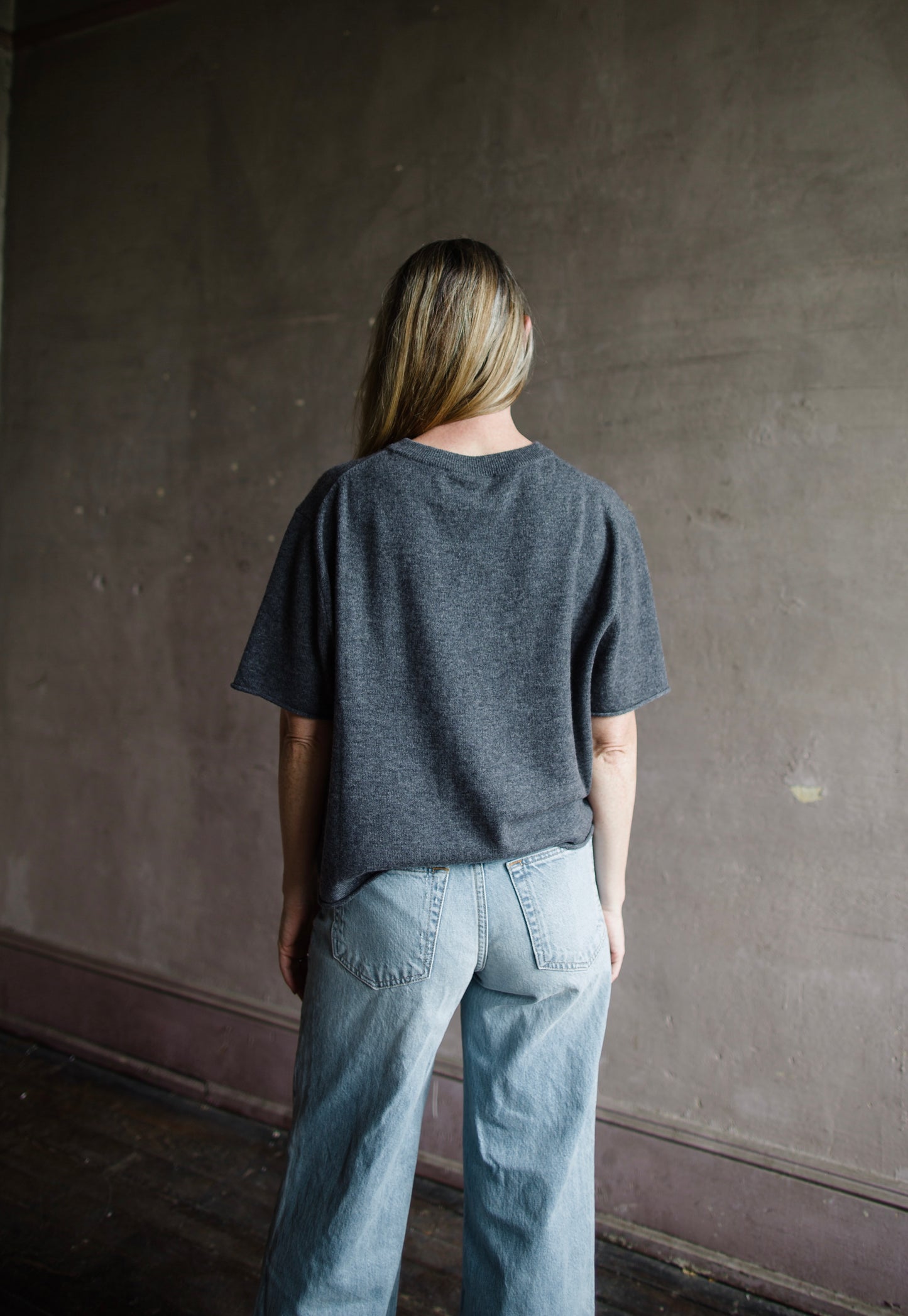 Image featuring a woman wearing the Cila tee by Lisa Yang  with a round neck, relaxed sleeve and rolled edges fabricated in luxury grey cashmere.