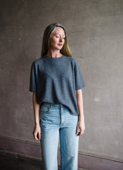 Image featuring a woman wearing the Cila tee by Lisa Yang  with a round neck, relaxed sleeve and rolled edges fabricated in luxury grey cashmere.