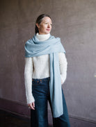 Image featuring a woman wearing the brushed cashmere scarf by Lisa Yang in powder blue.