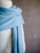 Detail close up image featuring a woman wearing the brushed cashmere scarf by Lisa Yang in powder blue.