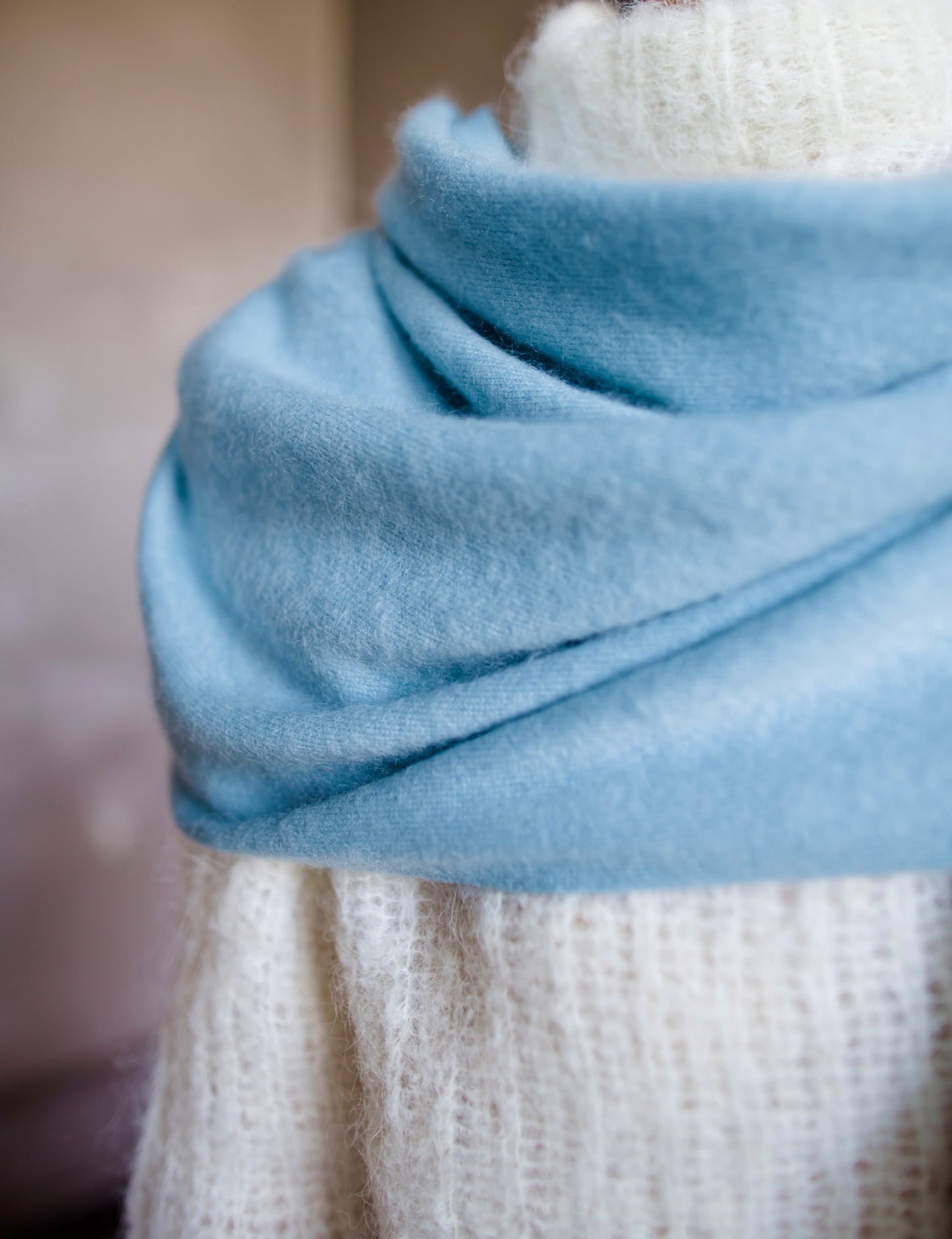 Detail close up image featuring a woman wearing the brushed cashmere scarf by Lisa Yang in powder blue.