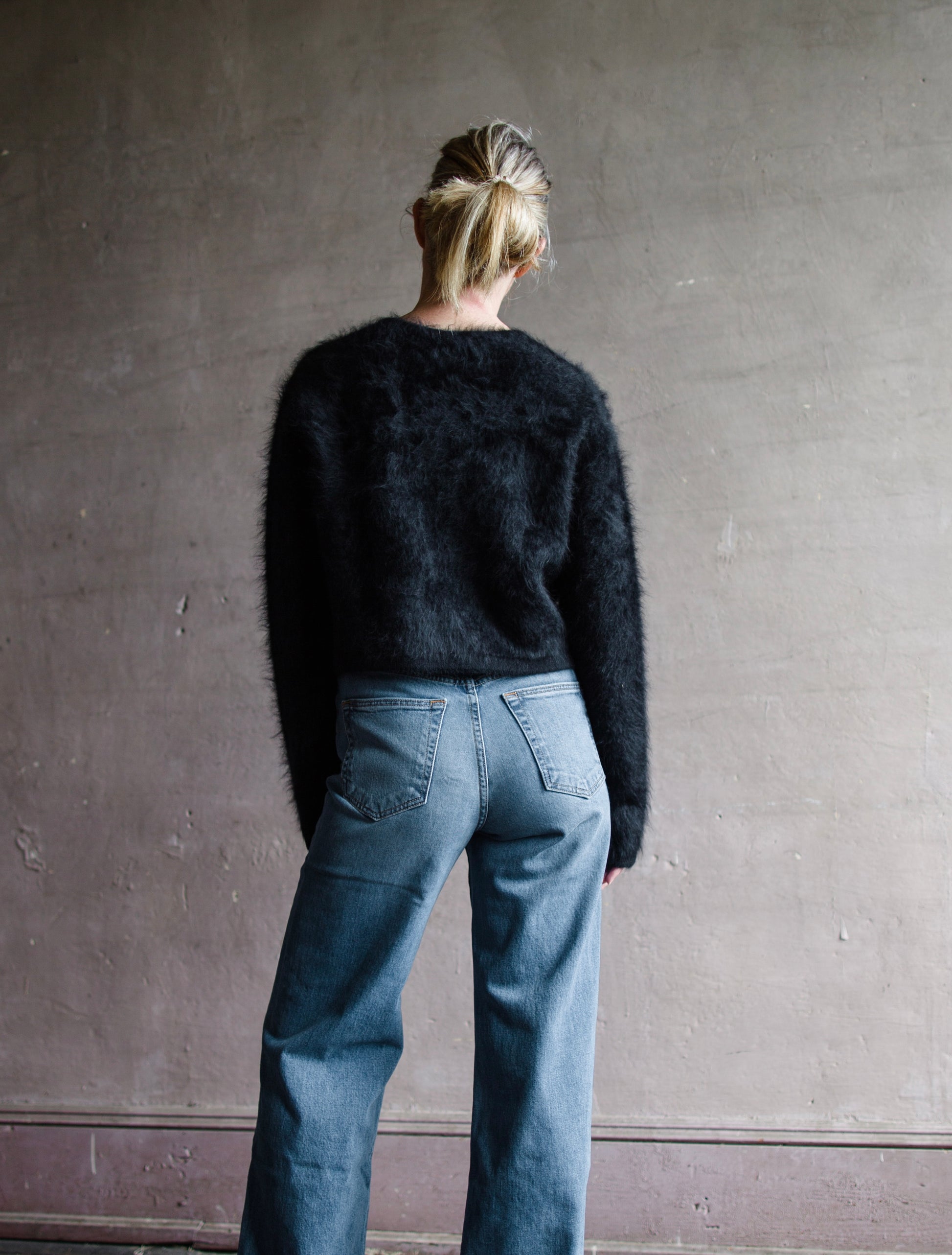 Image featuring a woman wearing the Filippa cardigan sweater by Lisa Yang with a button front and slightly cropped fit in the softest black brushed cashmere.