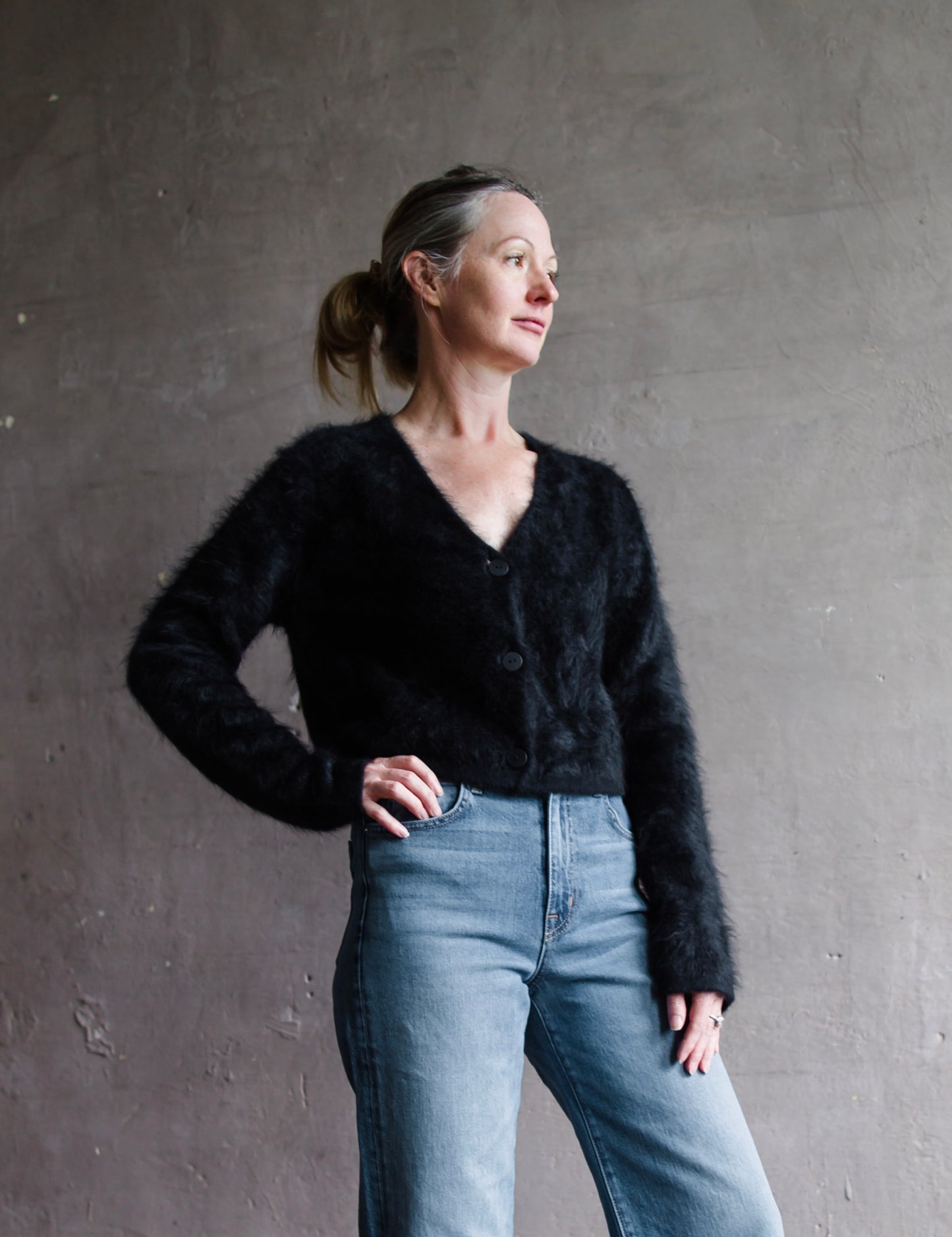 Image featuring a woman wearing the Filippa cardigan sweater by Lisa Yang with a button front and slightly cropped fit in the softest black brushed cashmere.