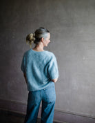 Image featuring a woman wearing the Lovisa sweater by Lisa Yang with a v neckline, short sleeves and in the softest powder blue brushed cashmere.