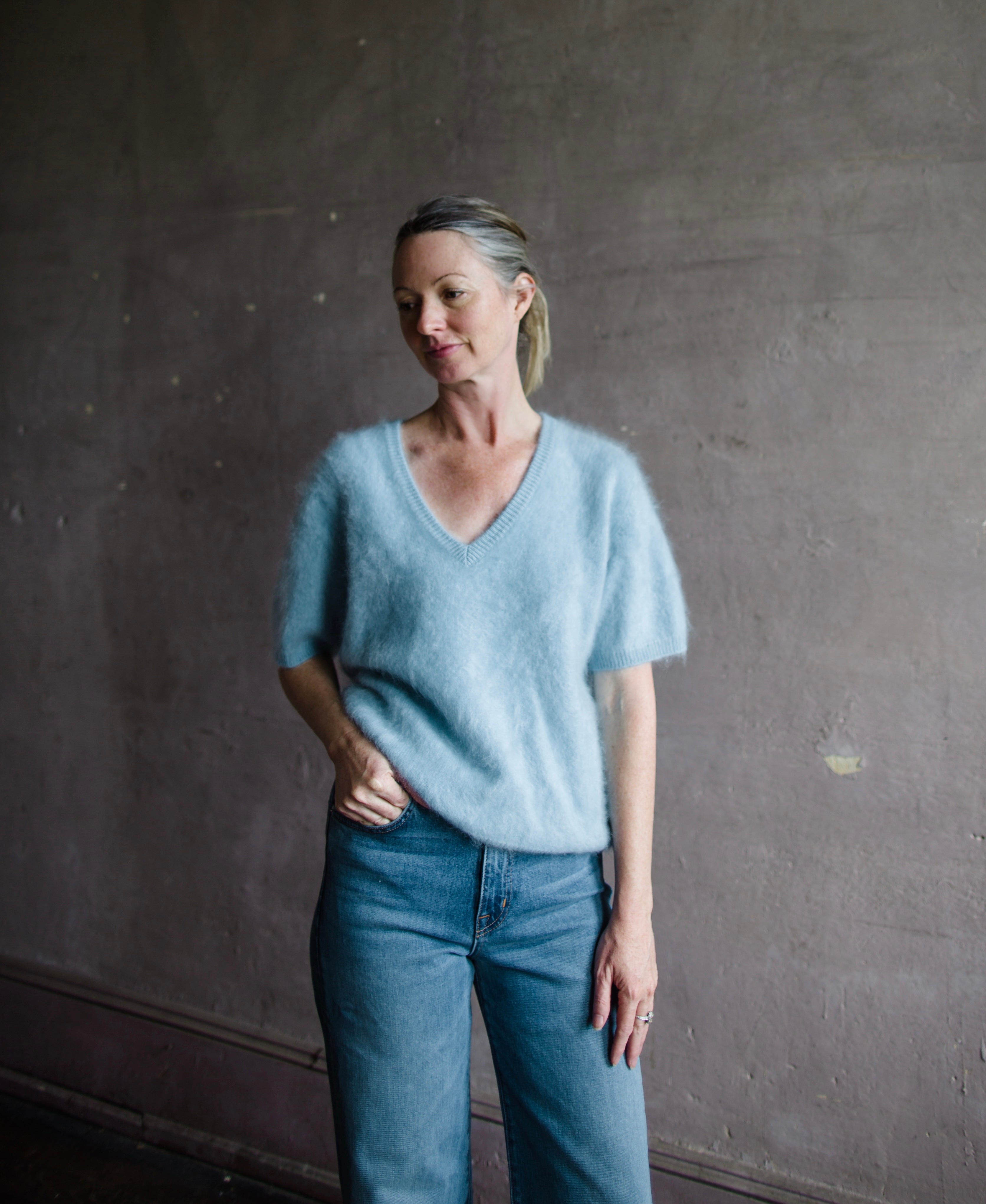 Image featuring a woman wearing the Lovisa sweater by Lisa Yang with a v neckline, short sleeves and in the softest powder blue brushed cashmere.