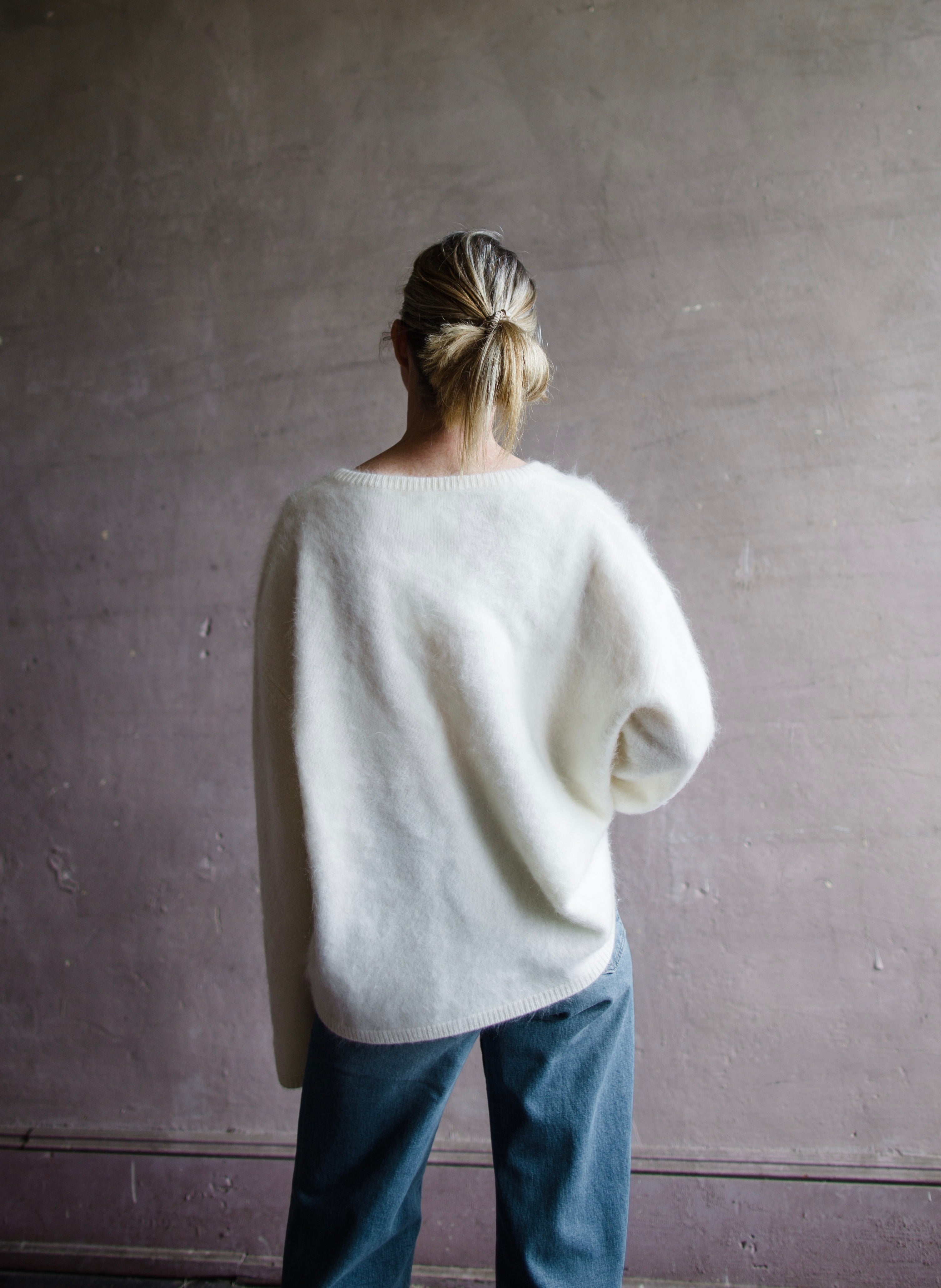 Image featuring a woman wearing the Margareta sweater by Lisa Yang with a deep v neckline, exaggerated sleeves in the softest ivory brushed cashmere.