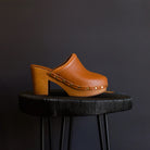 Image featuring M. Gemi shoes are slip on wooden sole clogs with exposed brass nail heads and medium brown Italian leather.