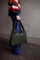 Image featuring a woman wearing the Candy Hobo by Mansur Gavriel in forest green with gold color zip closure and an interior pocket.