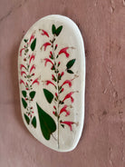 An oval ceramic tile with botanical black currant sage leaves pressed into cream-colored clay and air dried NC art