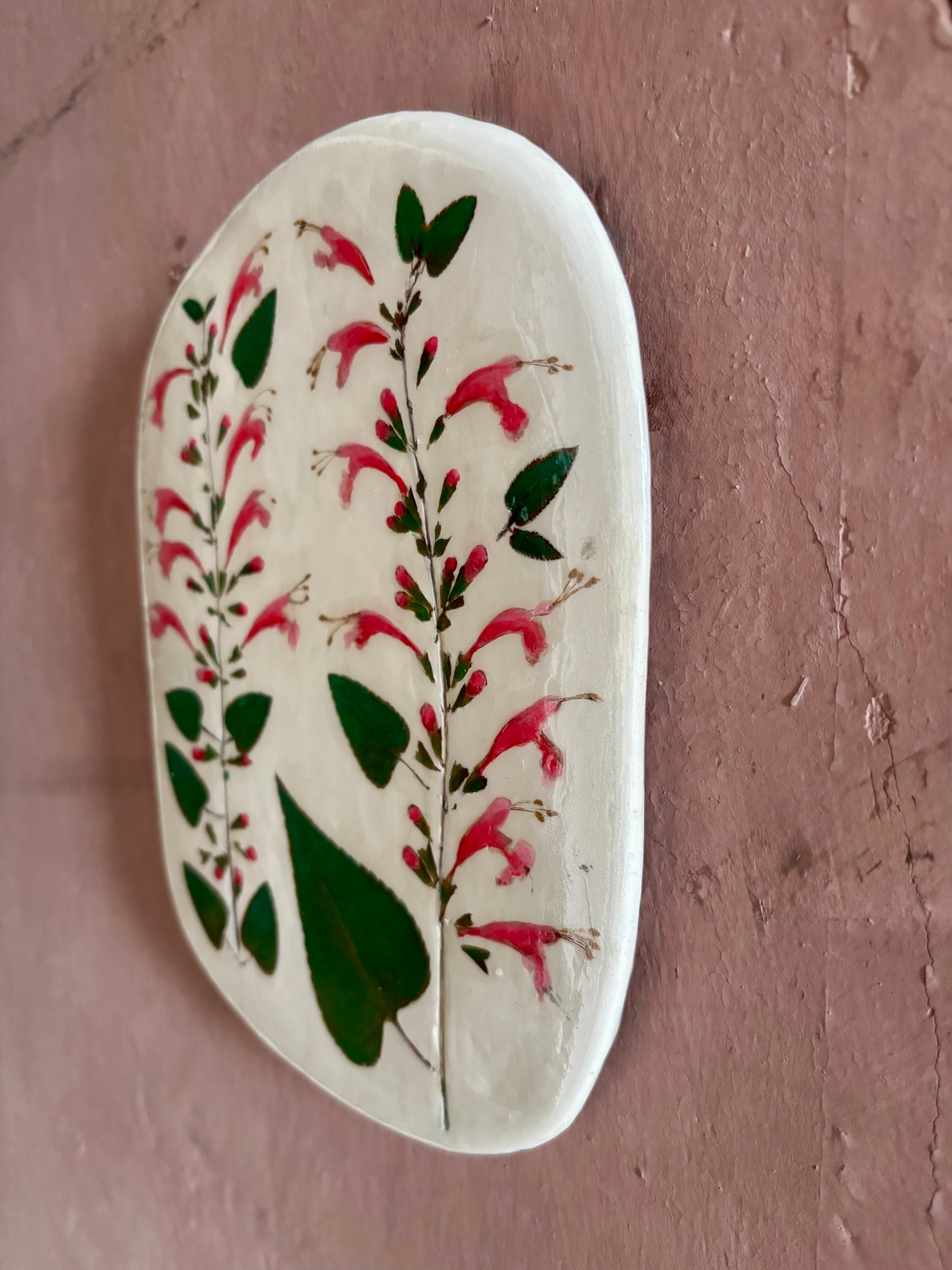 An oval ceramic tile with botanical black currant sage leaves pressed into cream-colored clay and air dried NC art